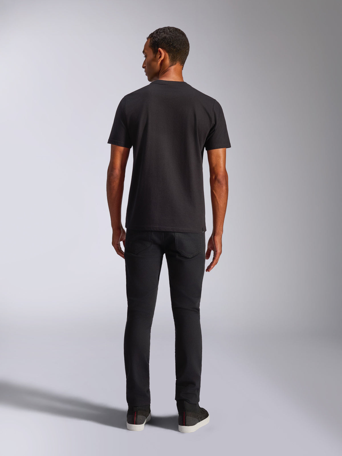 Alpinestars Blaze 2.0 CSF Tee, Kurzarm-T-Shirt, Schwarz, Rückansicht, getragen mit schwarzen Jeans, lässige vom Motorsport inspirierte Streetwear