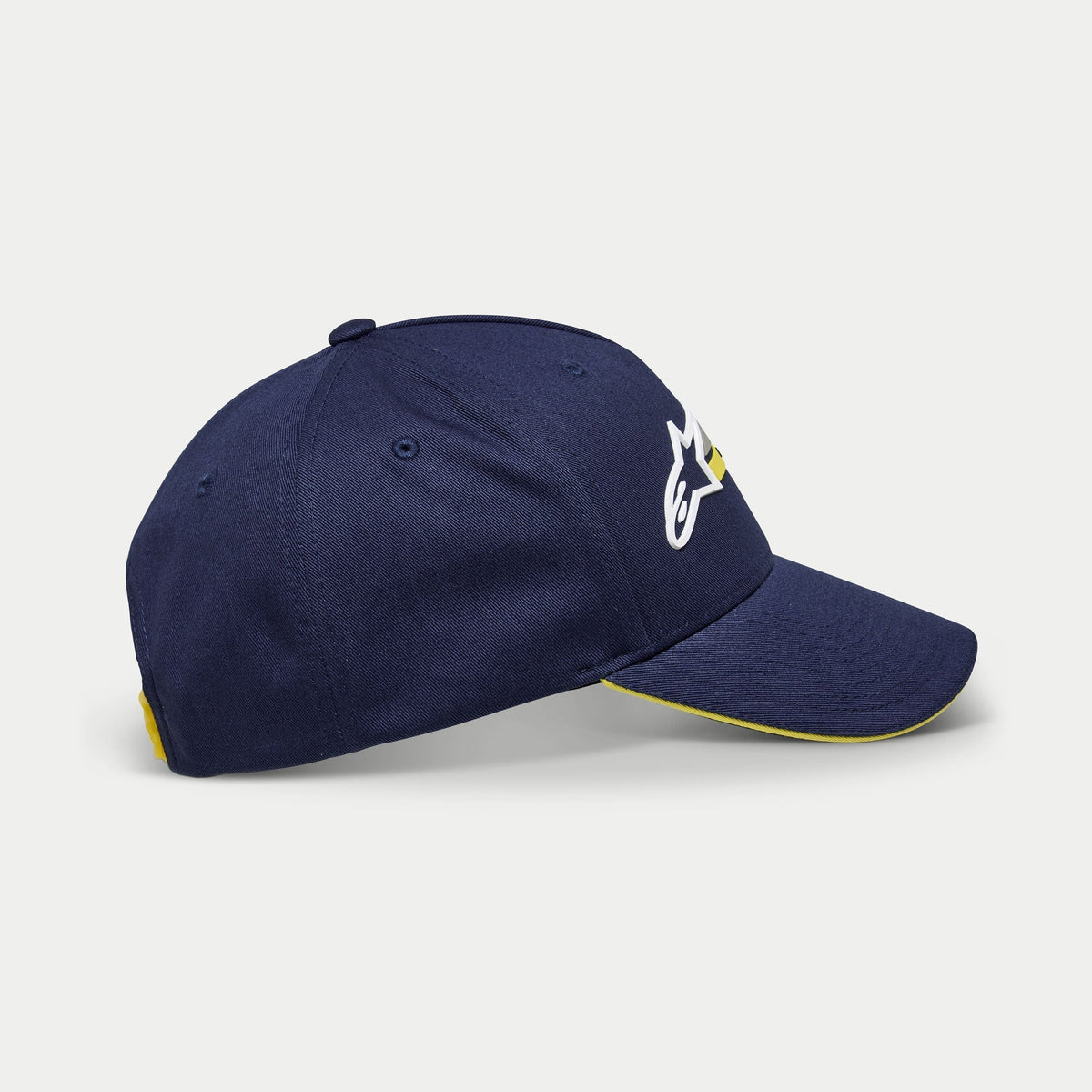 Alpinestars Par Hat, dunkelblaue Baseballkappe, Seitenansicht mit weißer und gelber Logo-Stickerei, gebogener Schirm mit gelbem Sandwich-Besatz, lässige strukturierte Kopfbedeckung