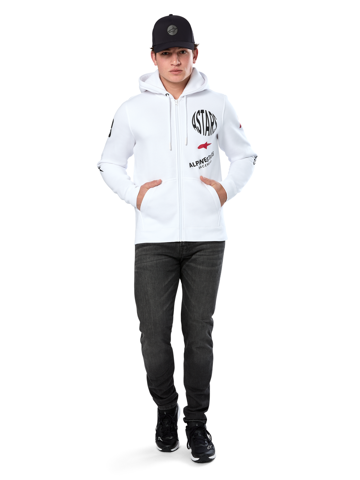Alpinestars Variegate Hoodie, White Zip-Up Fleece Hoodie, multi-logo artwork with 'ASTARS' and red star logo on chest, graphic details on sleeves, worn by model with black cap and black jeans, casual motorsport streetwear