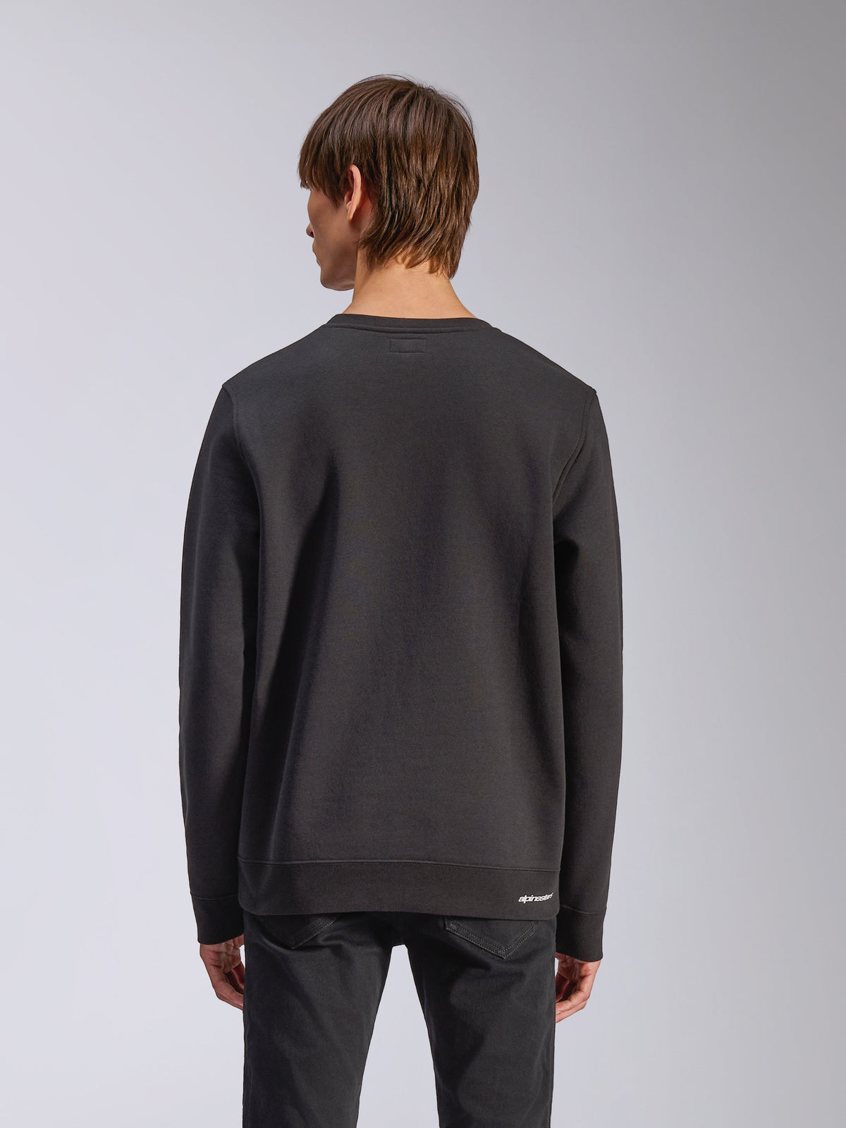 Alpinestars Positive Crew, pullover sweatshirt, zwart, achteraanzicht, met geribbelde manchetten en zoom en een klein wit logo op de heup, casual design geïnspireerd op de motorsport