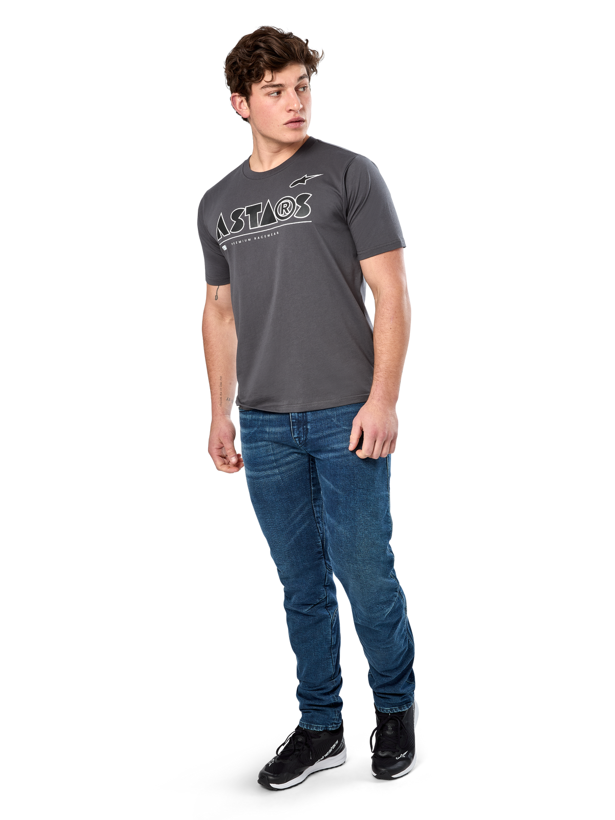 T-shirt Alpinestars Cereal CSF, T-shirt à manches courtes, anthracite, logo texte Astars géométrique blanc, streetwear décontracté style sport automobile porté avec un jean bleu et des baskets noires