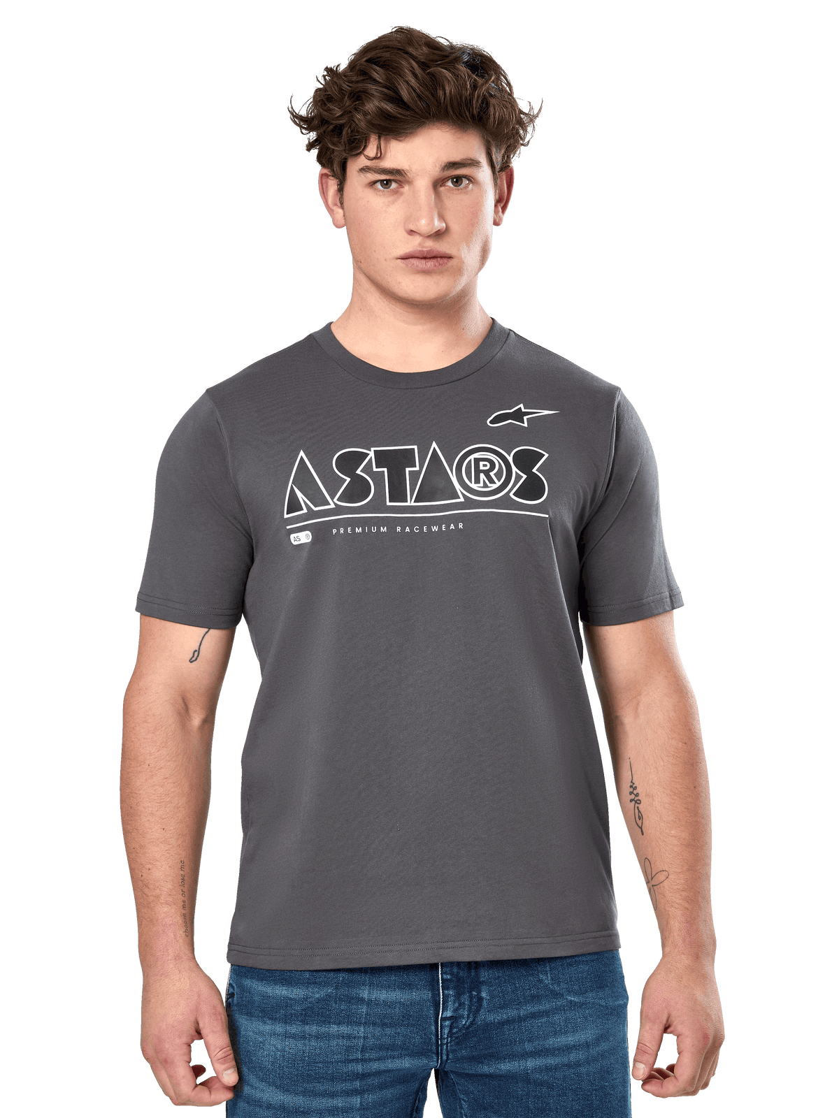 Alpinestars Cereal CSF Tee, t-shirt à manches courtes gris anthracite, porté par un mannequin homme avec un jean bleu, logo géométrique ASTARS blanc et inscription « Premium Racewear », vêtement lifestyle décontracté inspiré du sport automobile