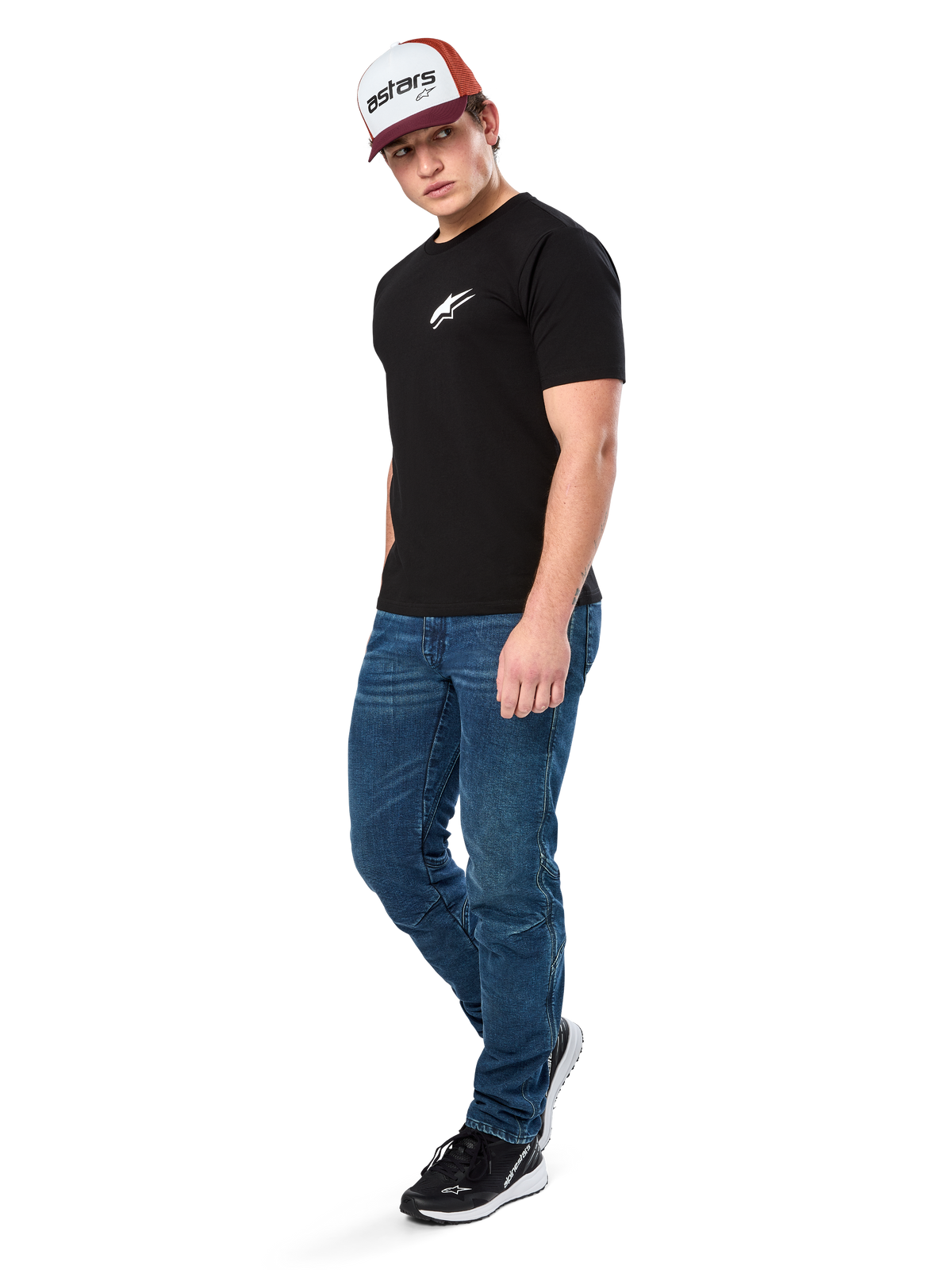 Alpinestars Formulate Csf Tee, T-shirt met korte mouwen, zwart met wit Astars-logo op de borst, gedragen door een model met blauwe jeans, een bordeauxrode en witte pet en zwarte sneakers, casual motorsport-geïnspireerde streetwear