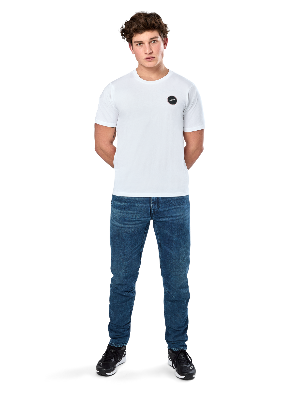 Alpinestars Dot Carbon Csf T-Shirt, Kurzarm-T-Shirt, Weiß, Rundes Astars-Logo in Carbonfaser-Optik, Lässige Motorsport-Streetwear, getragen von einem männlichen Model mit blauen Jeans und schwarzen Sneakern