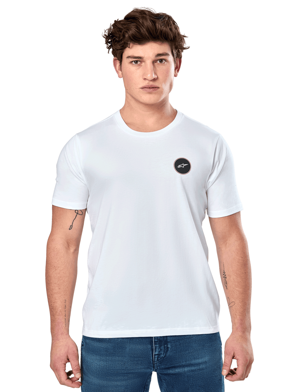 Alpinestars Dot Carbon CSF Tee, weißes Kurzarm-T-Shirt, männliches Model in weißem T-Shirt mit kleinem schwarzen kreisförmigen Logo auf der Brust und blauer Jeans, lässiger Motorsport-Stil