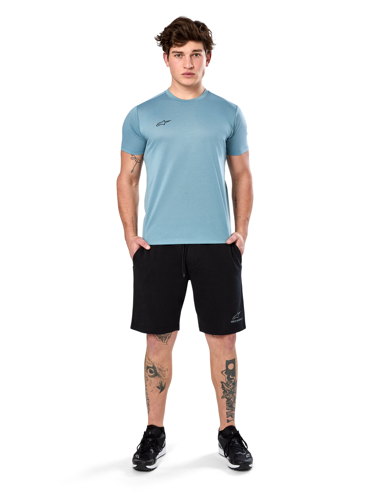 Alpinestars Point Performance Tee, T-shirt met korte mouwen, Ice Blue, met een klein zwart logo op de voorkant, ronde hals, gedragen door een model met zwarte shorts en zwarte sneakers, casual vochtafvoerende sportkleding