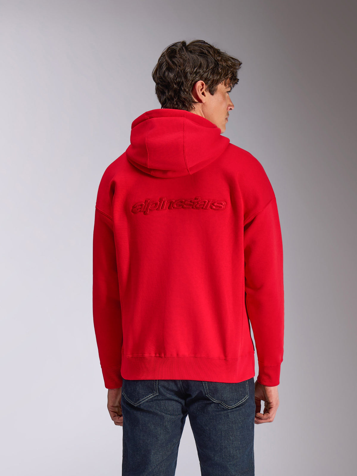 Alpinestars Emergent Oversized Hoodie, Rot, Rückansicht am Model, Ton-in-Ton 3D-gesticktes Alpinestars-Wortlogo, Oversized-Passform mit Rippbündchen an Saum und Ärmeln, lässige, vom Motorsport inspirierte Streetwear