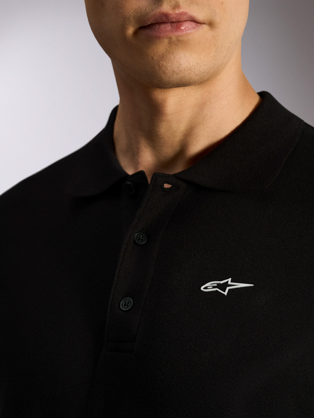 Alpinestars Endeavor Classic Polo, zwarte piqué polo met korte mouwen, knoopsluiting met drie knopen, geribde kraag, witte Astars logo HD-print, casual streetwear geïnspireerd op de motorsport