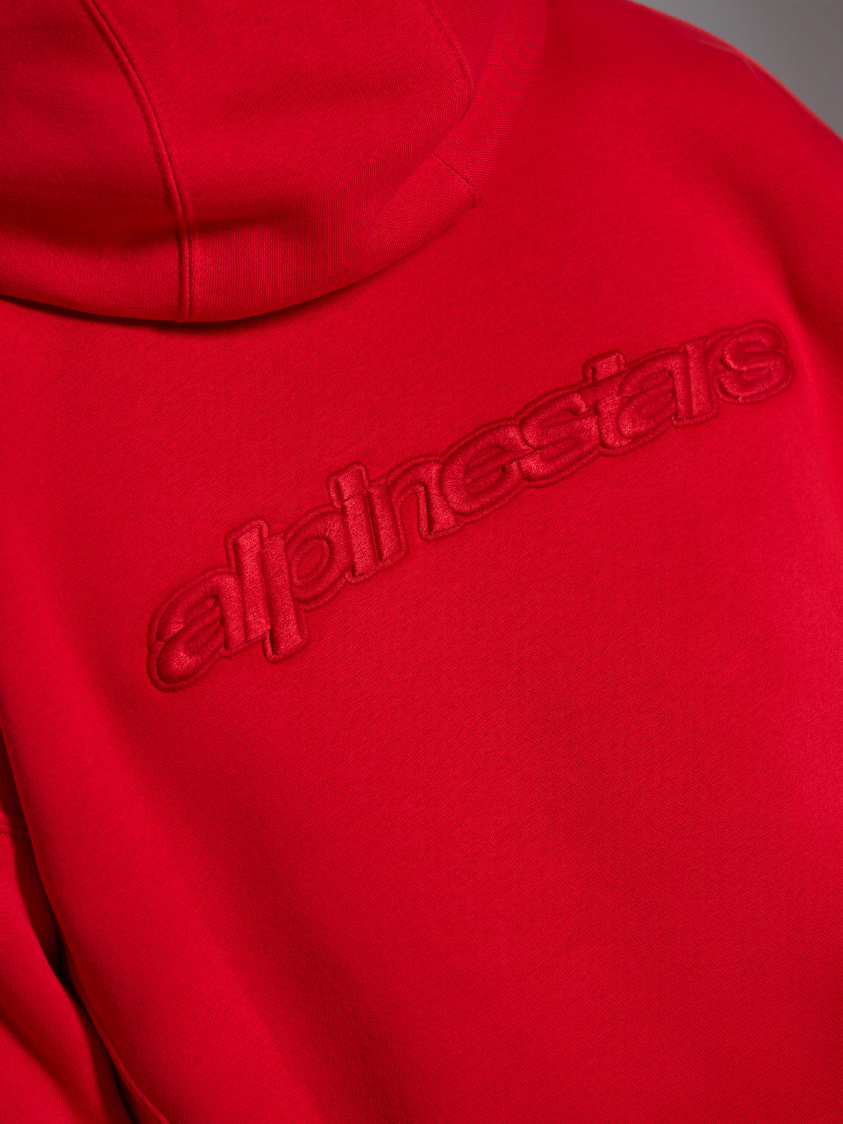 Alpinestars Emergent Oversized Hoodie, Rot, Nahaufnahme der Rückseite mit tonalem 3D-gesticktem Alpinestars Wortlogo, erhabenes monochromes Branding auf Fleece-Gewebe