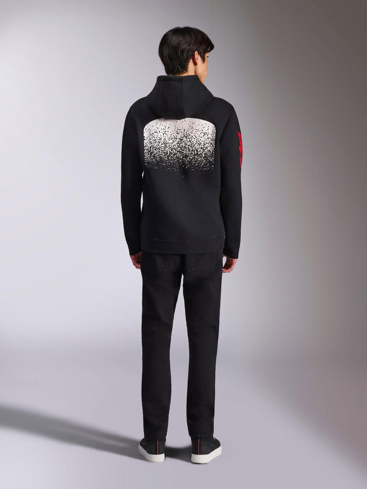 Sweat à capuche Alpinestars Obsessed, sportswear décontracté, noir avec graphisme en dégradé MX blanc au dos, logo rouge sur la manche, vue de dos, porté avec un pantalon noir