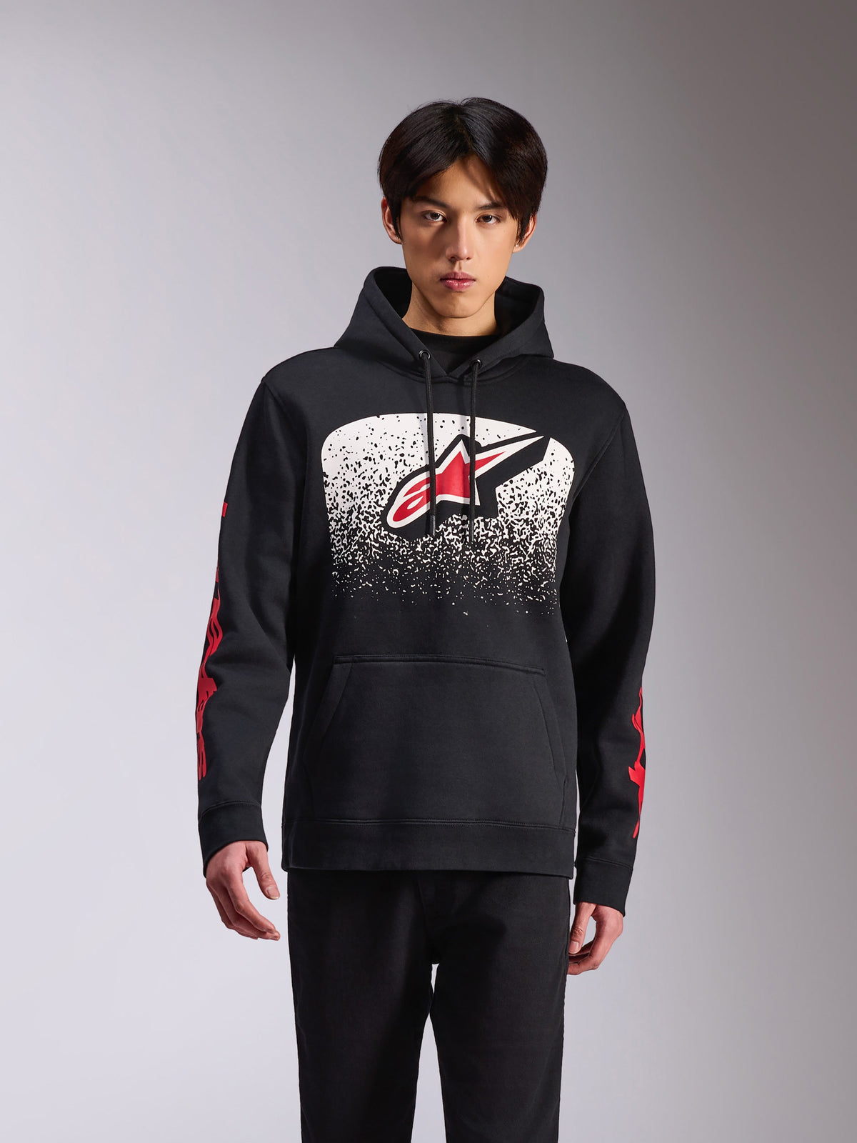 Alpinestars Obsessed Hoodie, sportswear décontracté, sweat à capuche noir arborant un grand logo Astars sur le devant avec un dégradé MX moucheté blanc et noir, marquage rouge sur les manches, capuche à cordon de serrage et poignets côtelés