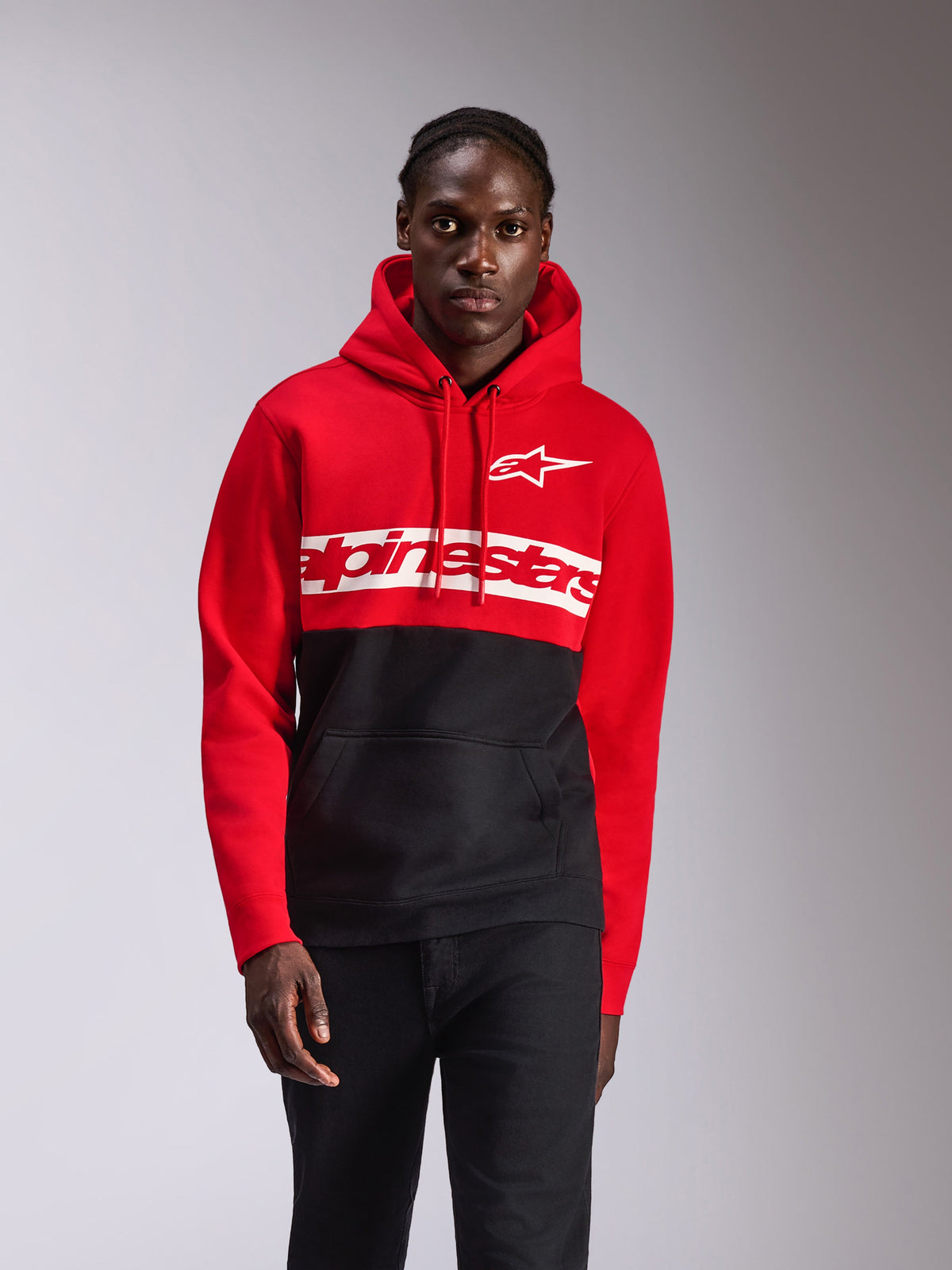 Alpinestars Parallel Hoodie, casual streetwear, kleurgeblokkeerd rood en zwart, groot wit Alpinestars woordlogo en Astars logo op de borst, capuchon met trekkoord, kangoeroezak aan de voorkant, motorsport-geïnspireerd ontwerp