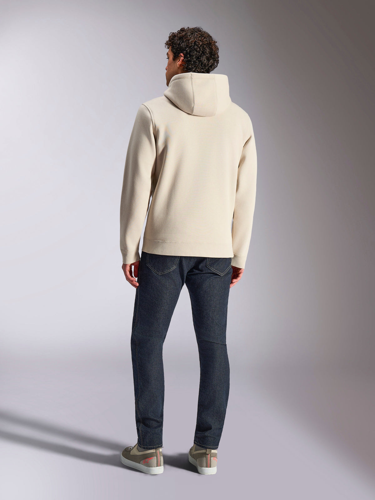 Alpinestars Pulse Hoodie, Blanc cassé, vue de dos d'un homme portant un sweat à capuche décontracté en polaire avec un jean foncé et des baskets, design sportswear moderne