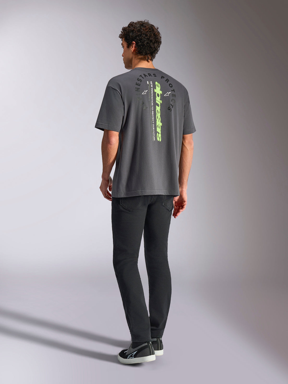 Alpinestars Overhang Oversized CSF Tee, T-shirt met korte mouwen, antracietgrijs, voorzien van een verticaal limoengroen woordmerk en ronde Alpinestars Protects-grafiek op de achterkant, casual motorsport streetwear