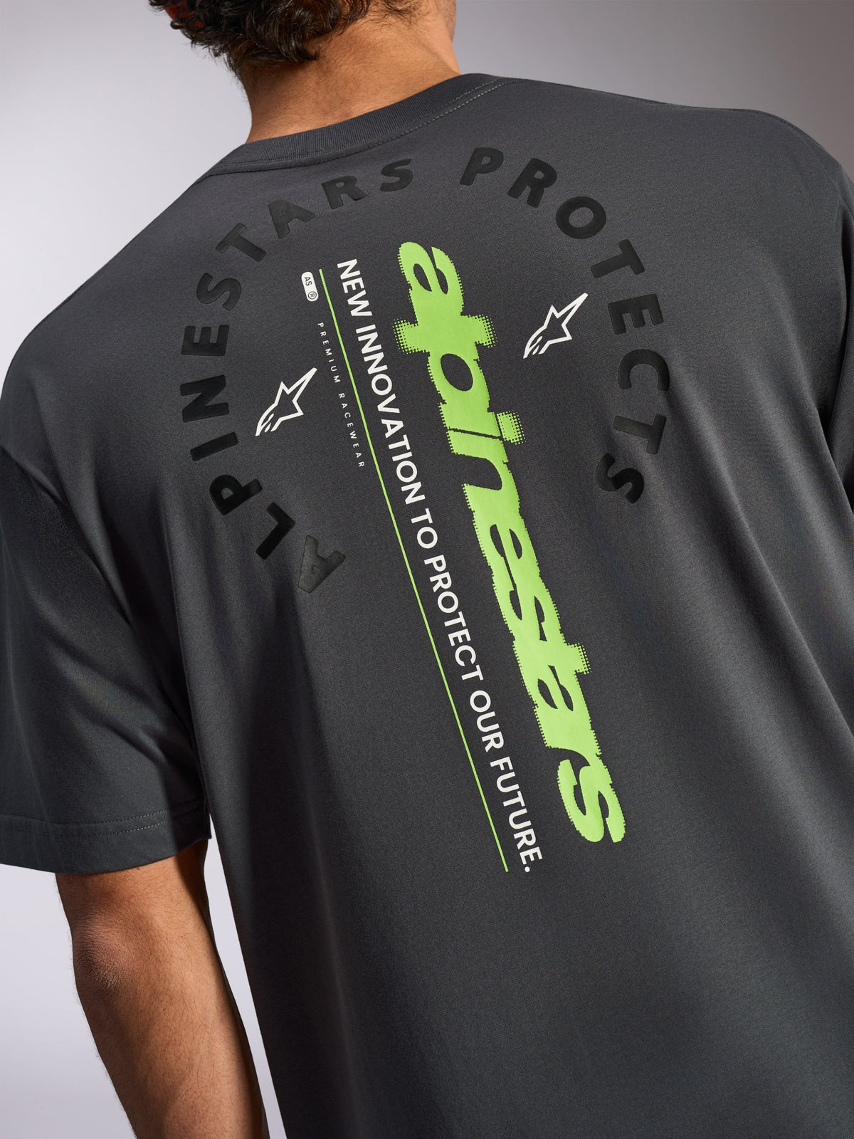 Alpinestars Overhang Oversized CSF T-shirt, shirt met korte mouwen, antracietgrijs, achteraanzicht met een groot verticaal limegroen logo en zwarte Alpinestars Protects graphic, casual motorsport-geïnspireerde sportkleding
