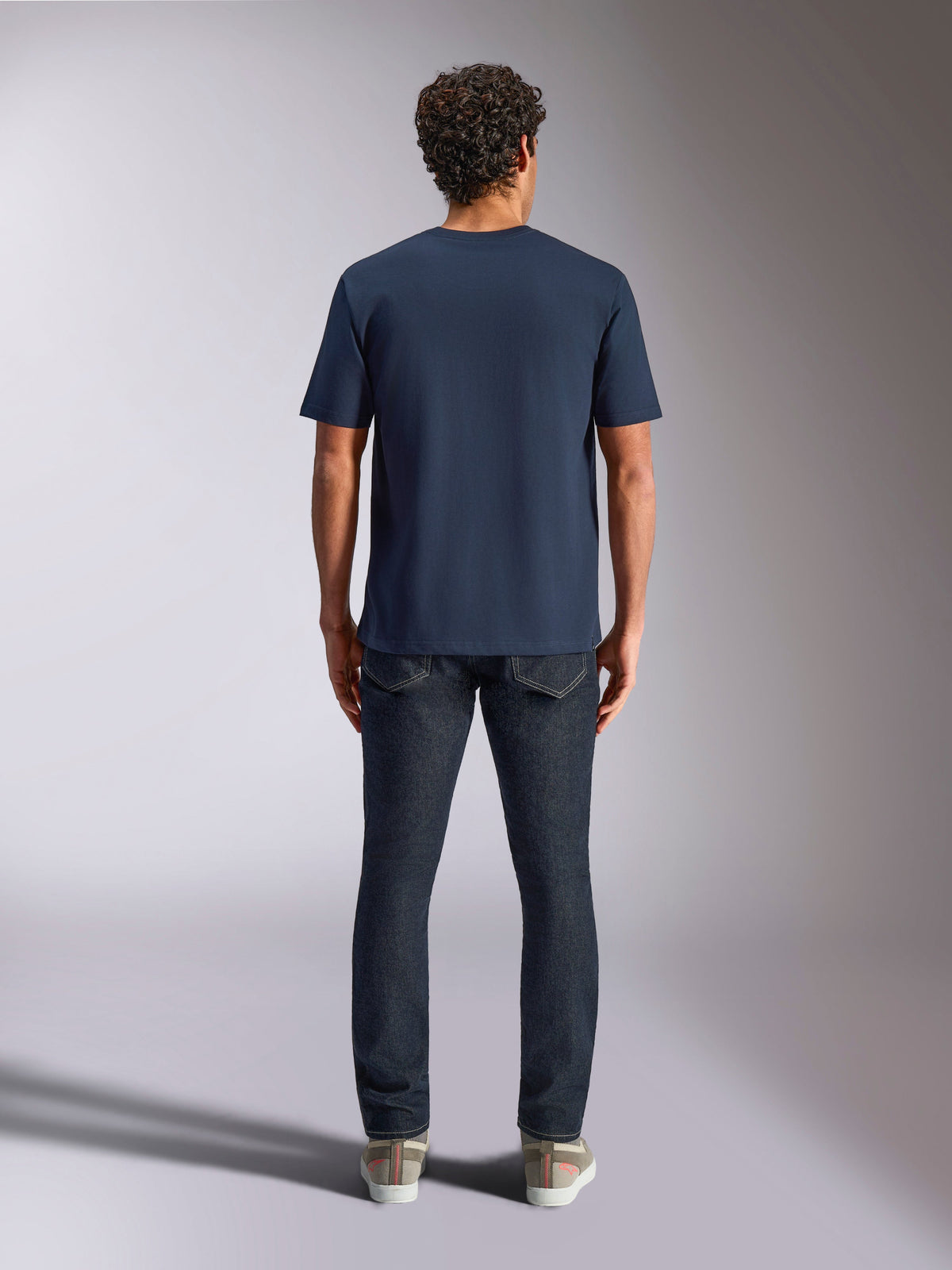 Alpinestars Trifecta CSF Tee, kurzärmeliges T-Shirt, Marineblau, Rückansicht am Modell, kombiniert mit dunkler Jeans und lässigen Sneakern, lässige Motorsport-Streetwear