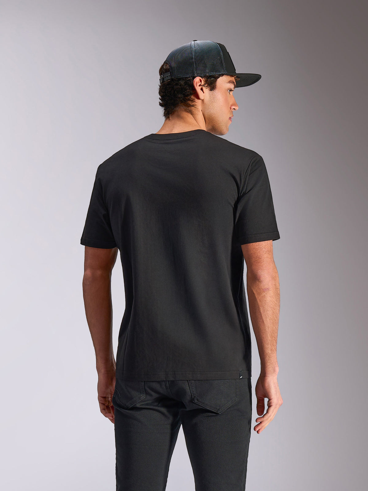 Alpinestars Verdure Camo CSF Tee, T-shirt met korte mouwen, zwart, achteraanzicht, gedragen met een mesh back cap en een zwarte broek, casual motorsport streetwear
