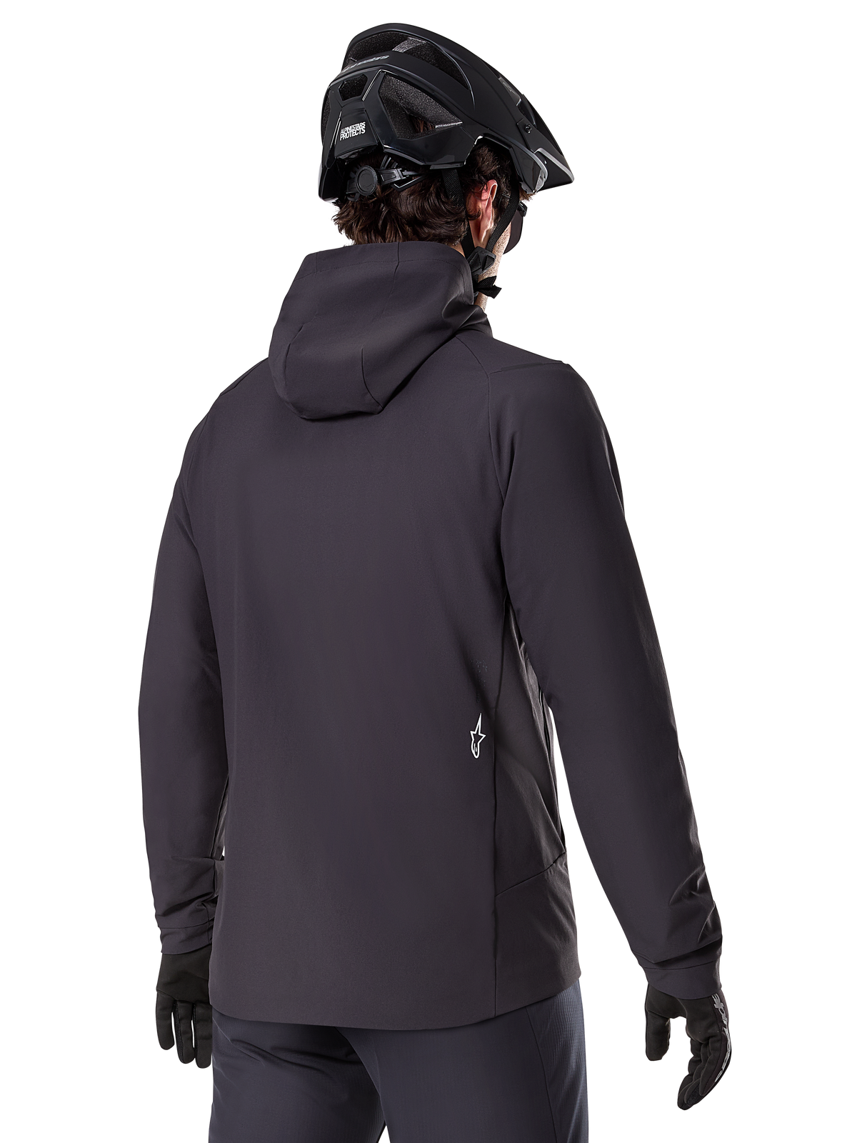 Veste thermique Alpinestars A-Dura, noire, vue de dos, portée avec un casque de VTT noir et des gants, avec un petit logo Astars blanc dans le bas du dos, veste de cyclisme légère et isolante