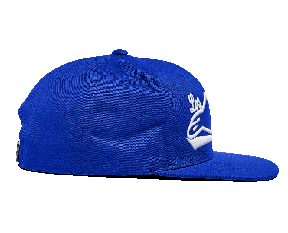 Casquette Alpinestars Los Angeles, casquette snapback bleue, vue de profil, dotée d'une visière plate et d'une couronne structurée, sergé de coton bleu vif avec broderie 3D blanche, sportswear décontracté.