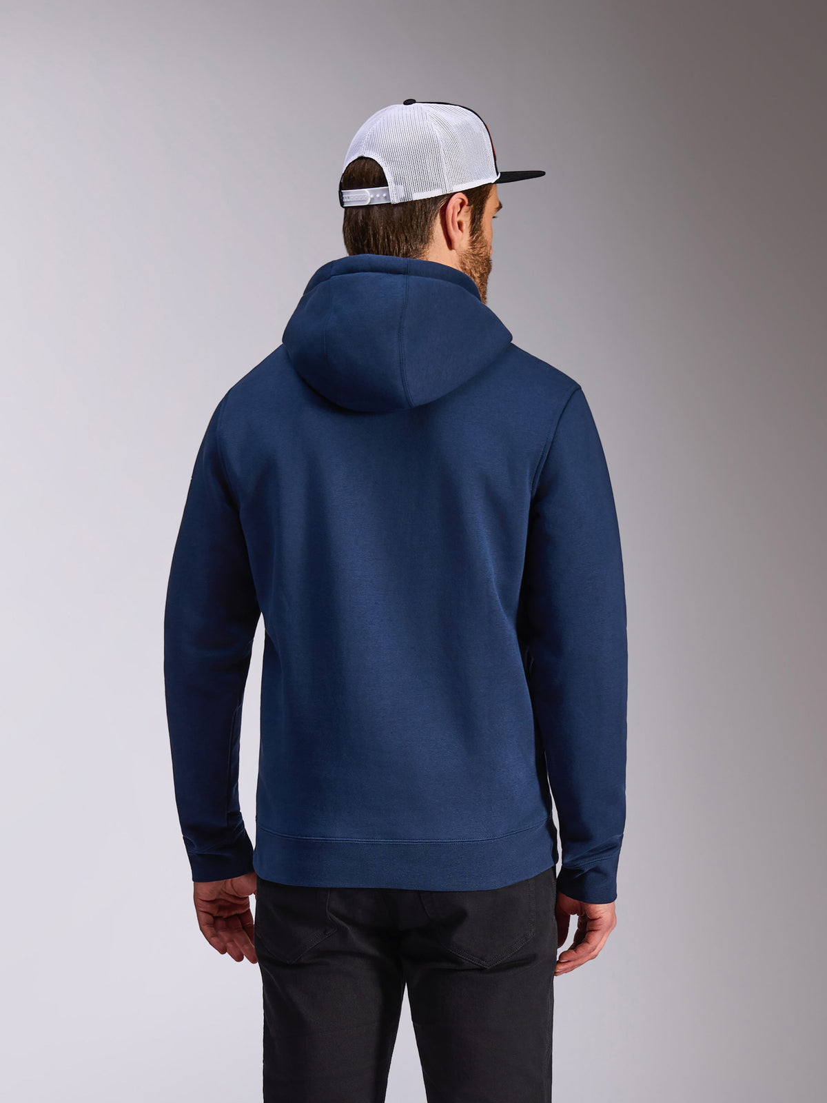 Sweat à capuche Frontal Alpinestars, sweat en polaire bleu marine, vue de dos d'une tenue streetwear décontractée, porté avec un pantalon noir et une casquette mesh blanche et noire, design moderne inspiré des sports mécaniques