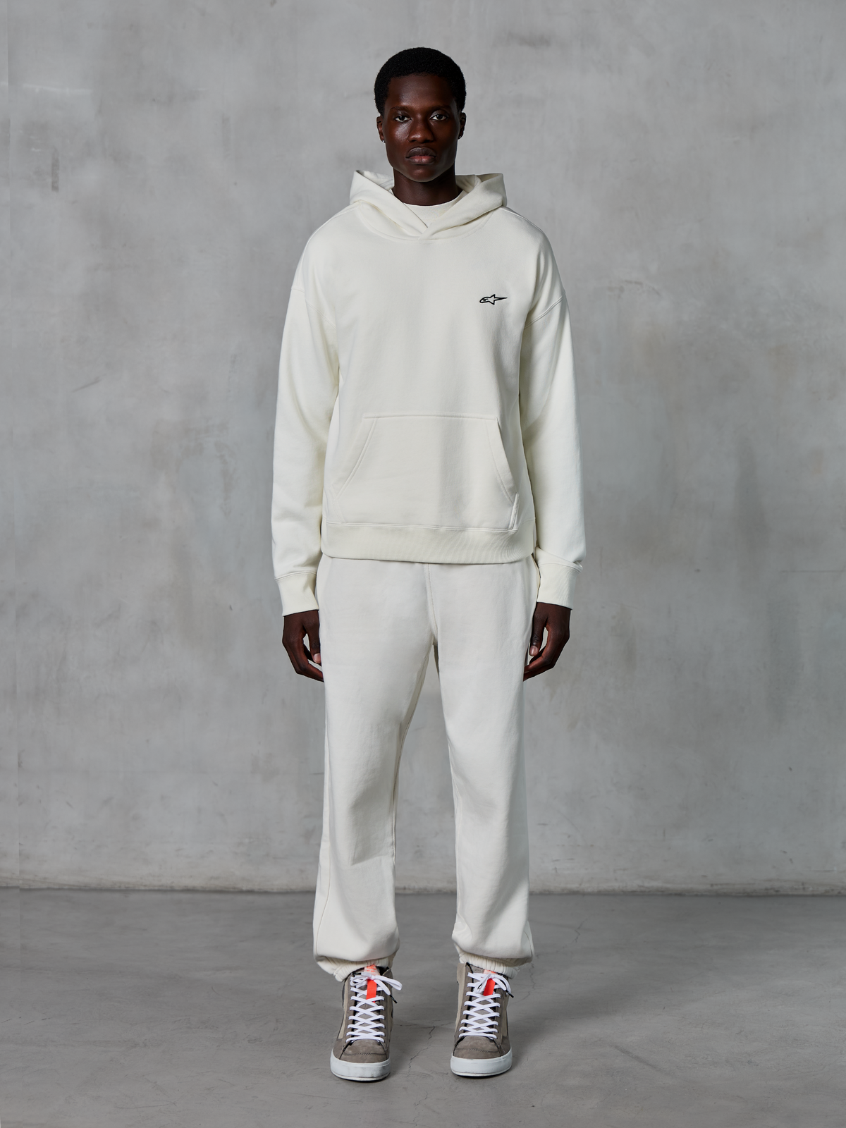 Alpinestars Essentials Ageless Hoodie, pullover hoodie, off-white, voorzien van een capuchon met trekkoord en kangoeroezak, stone-washed compact fleece, casual motorsport-geïnspireerde streetwear