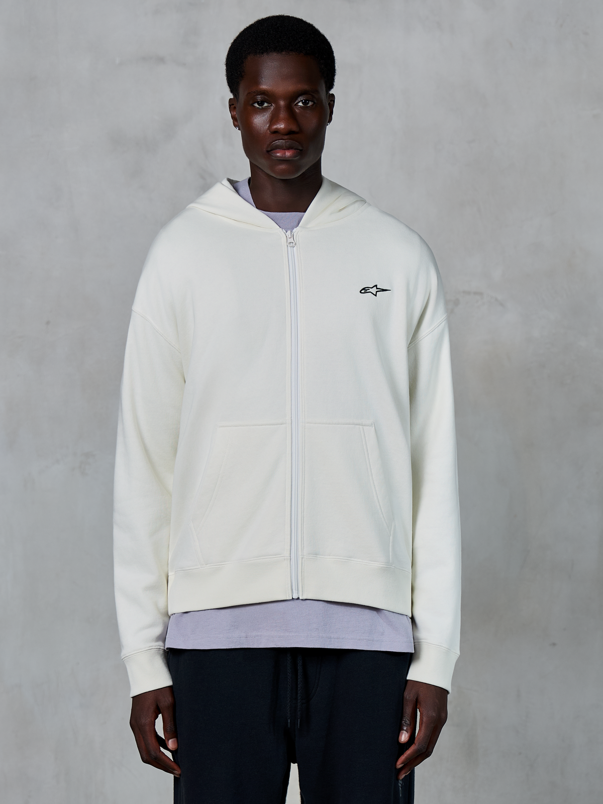 Alpinestars Essentials Ageless Zip Hoodie, sweat à capuche zippé décontracté blanc cassé, capuche à cordon de serrage, poignets et ourlet côtelés, marquage subtil, vêtement lifestyle premium inspiré par le sport automobile