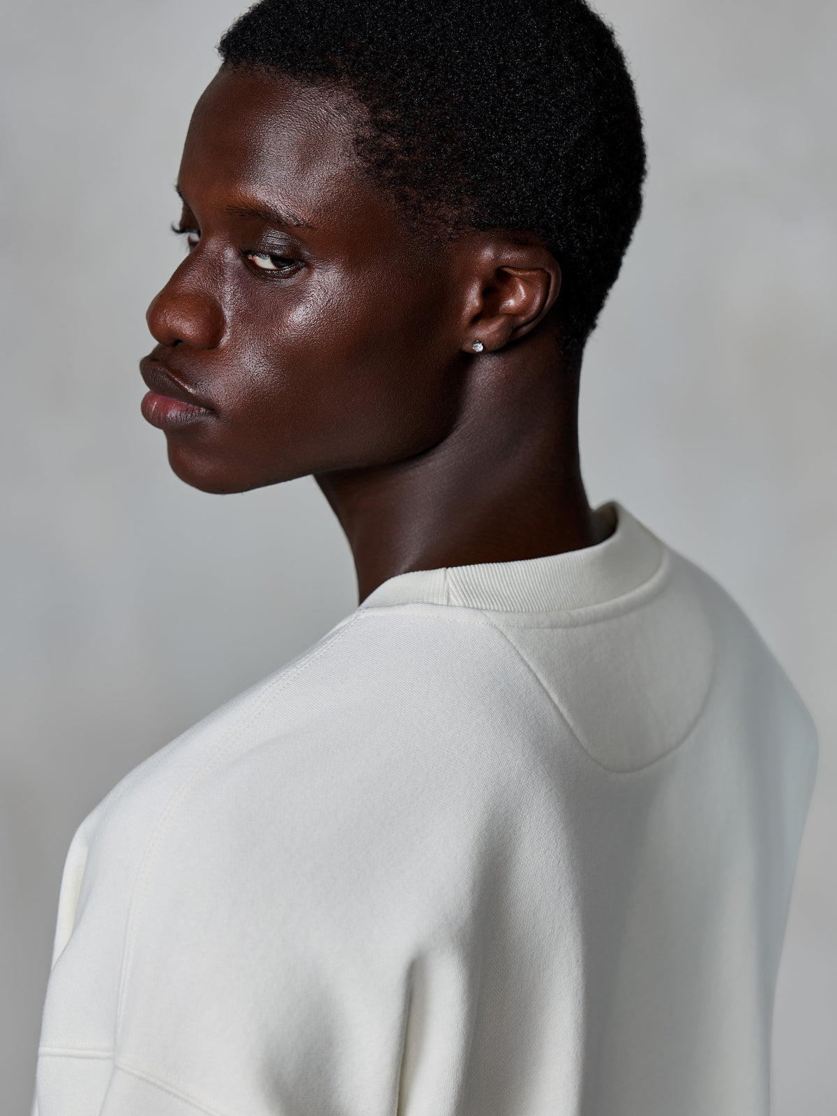 Alpinestars Essentials Ageless Crew, crewneck sweatshirt, off-white, close-up van de achterzijde op model met de geribbelde halslijn en premium fleece textuur, casual lifestyle streetwear