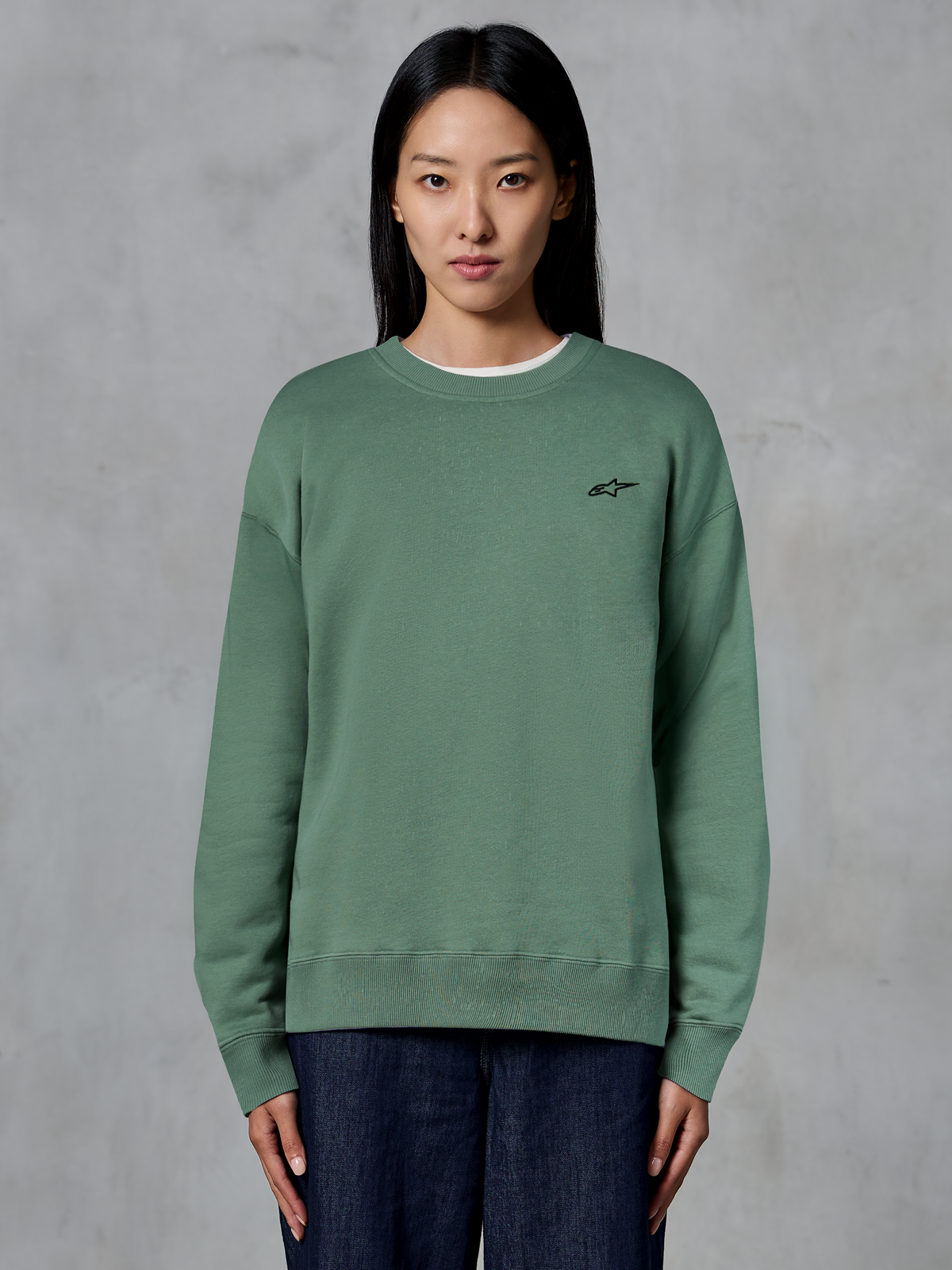 Alpinestars Essentials Ageless Crew, sweat-shirt à col rond, vert cactus, porté par un mannequin, petit logo noir sur la poitrine, col, poignets et ourlet côtelés, streetwear décontracté