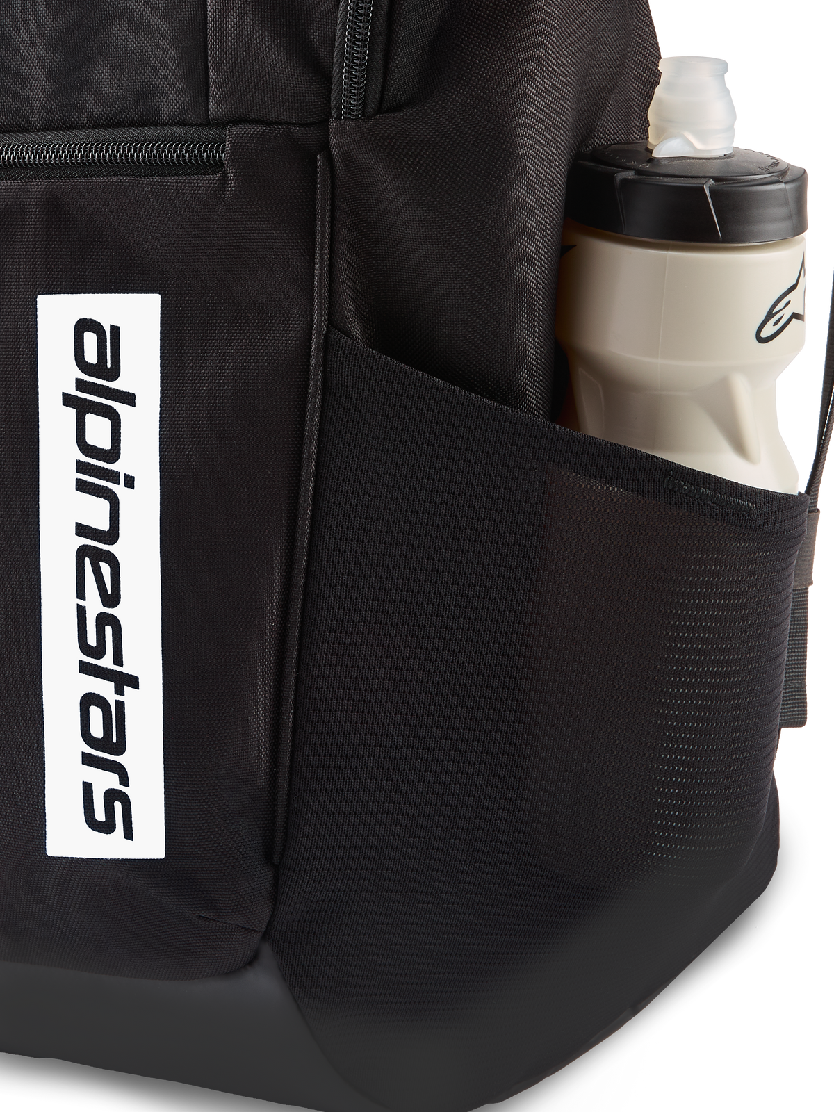 Alpinestars Defcon V3 Rucksack, schwarzer Tagesrucksack, Nahaufnahme der seitlichen Netztasche mit Wasserflasche, vertikales weißes Logo-Branding auf der Vorderseite, strapazierfähiges 600D-Polyester-Material