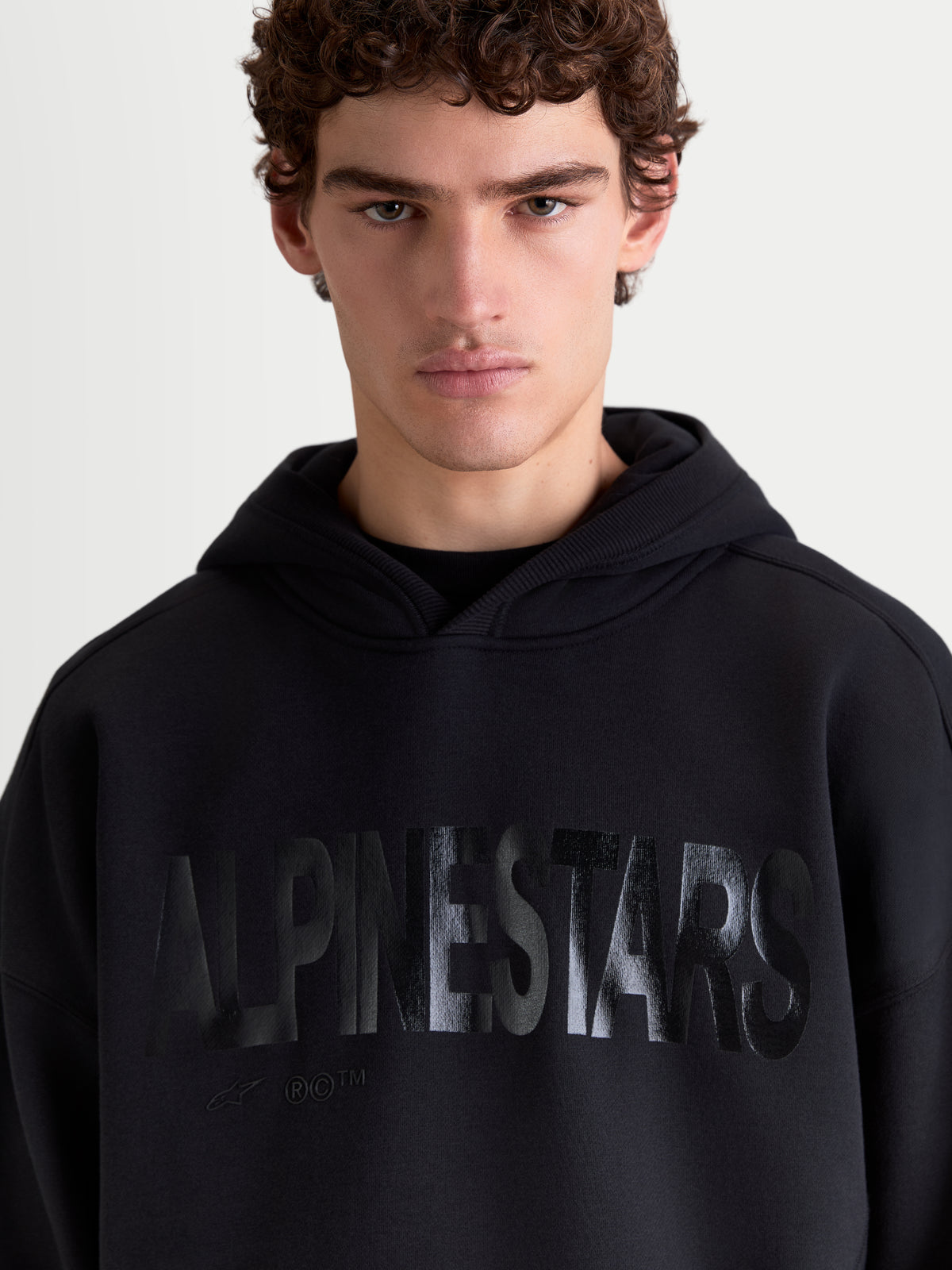 Alpinestars Shaw oversized hoodie, zwarte sportswear-pullover voor heren en dames, met een tonaal getextureerd woordlogo op de borst, relaxte oversized pasvorm, gemaakt van zachte fleece katoenmix met een zelfgevoerde capuchon.