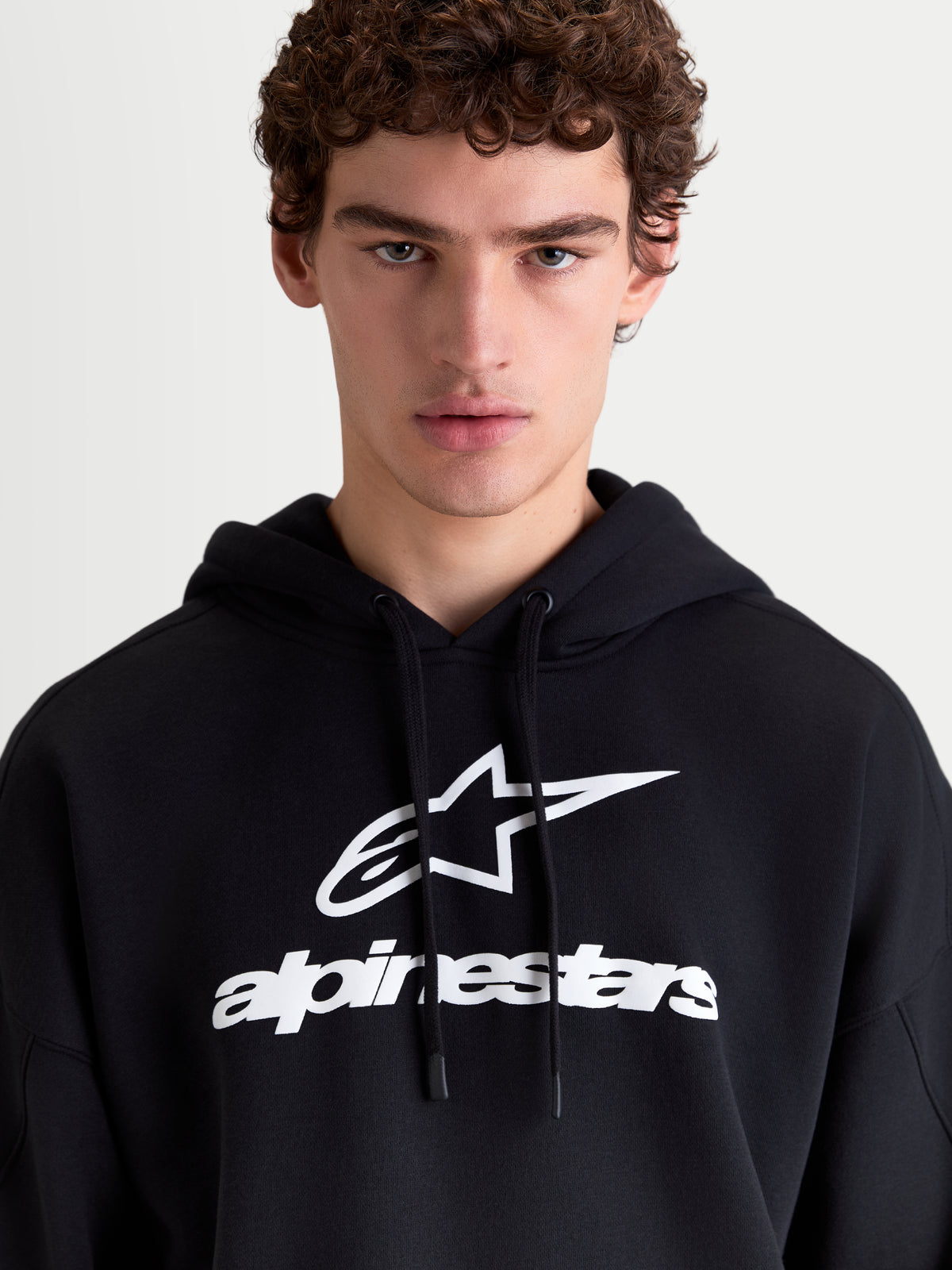 Alpinestars Prelude Oversized Hoodie, sweat à capuche de style sportswear pour homme, noir et blanc, avec un logo en relief sur la poitrine, capuche doublée avec cordons plats et coupe ample pour un confort quotidien