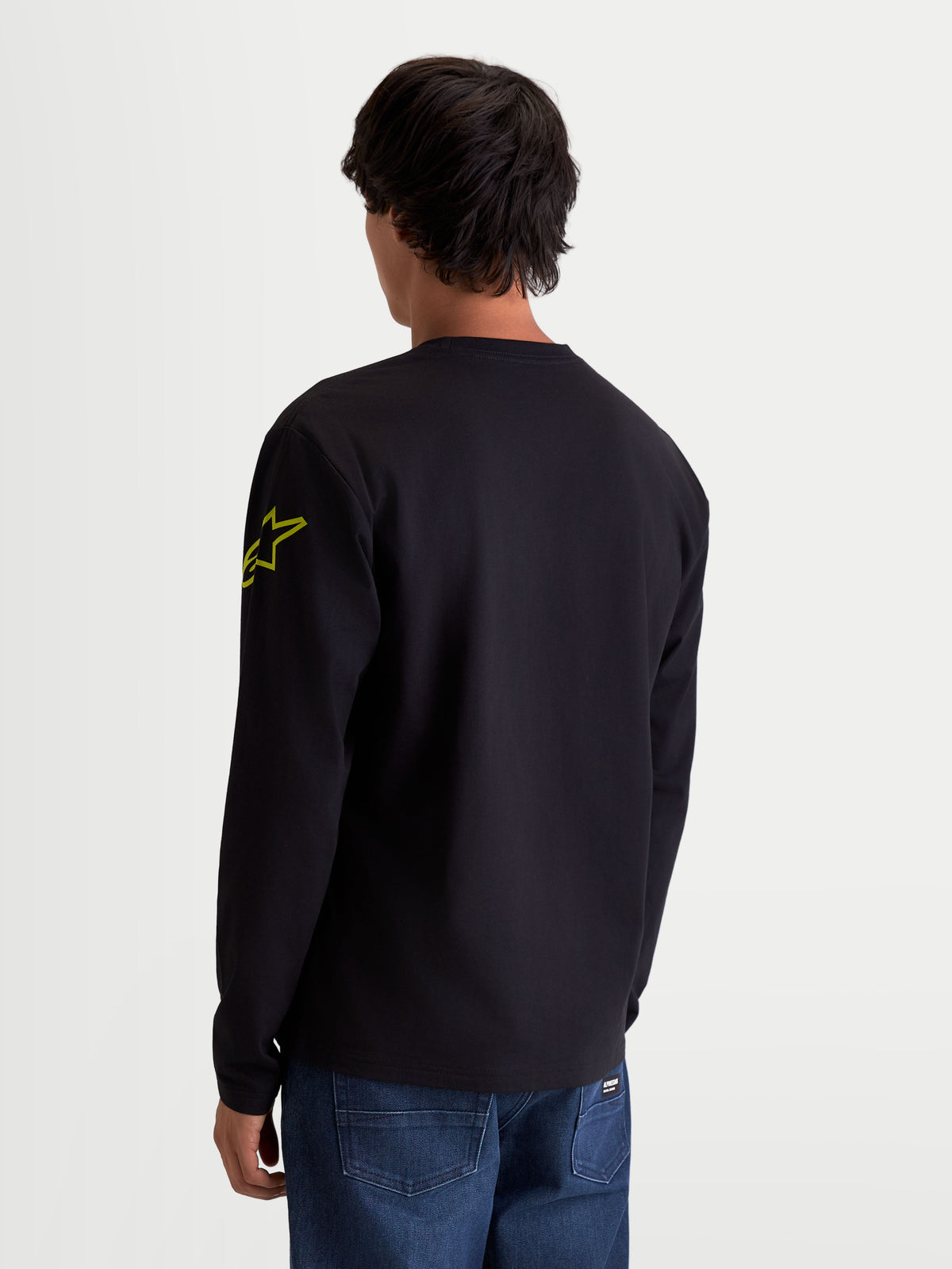 Alpinestars Velocifier CSF, t-shirt sportswear à manches longues, noir et jaune, vue de dos sur modèle avec logo Astars sur la manche et poignets côtelés, confectionné en mélange de coton et polyester recyclé.