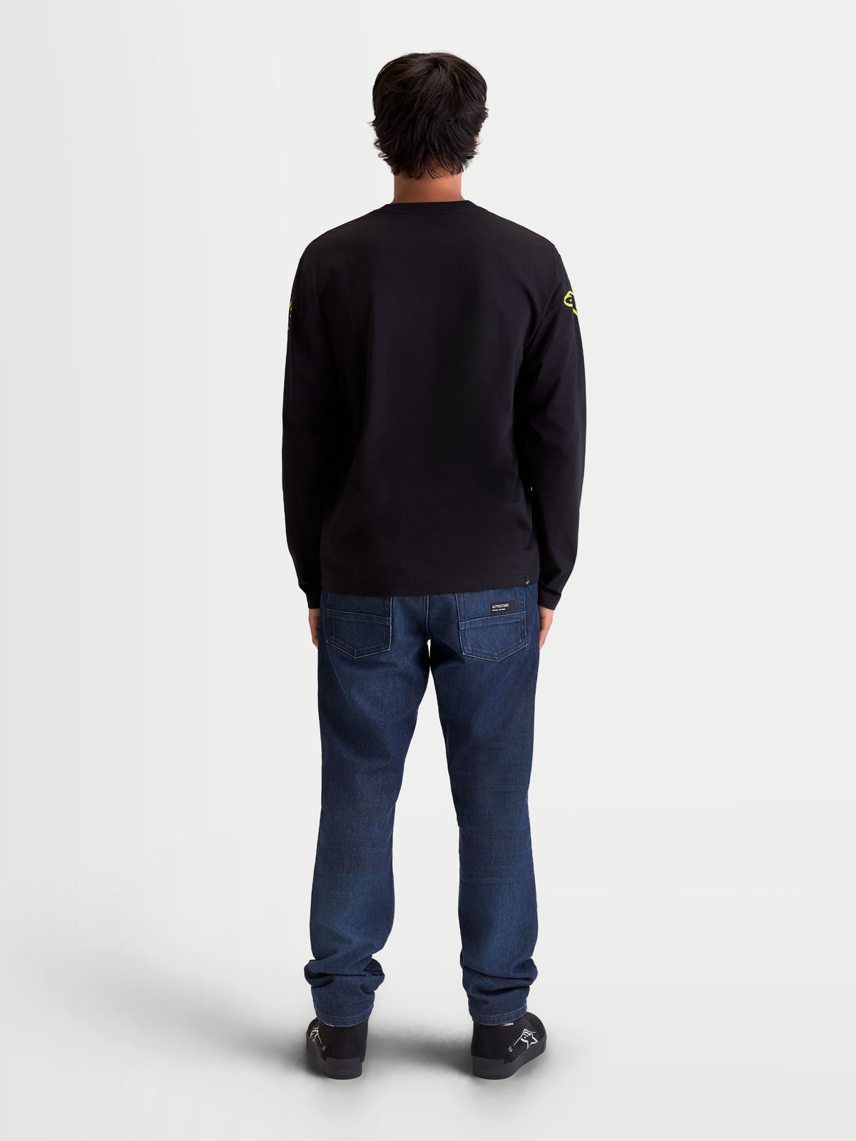 Alpinestars T-Shirt Velocifier CSF, t-shirt sportswear à manches longues, vue de dos sur modèle, noir avec logos jaunes sur les épaules, mélange de coton et polyester recyclé, poignets côtelés