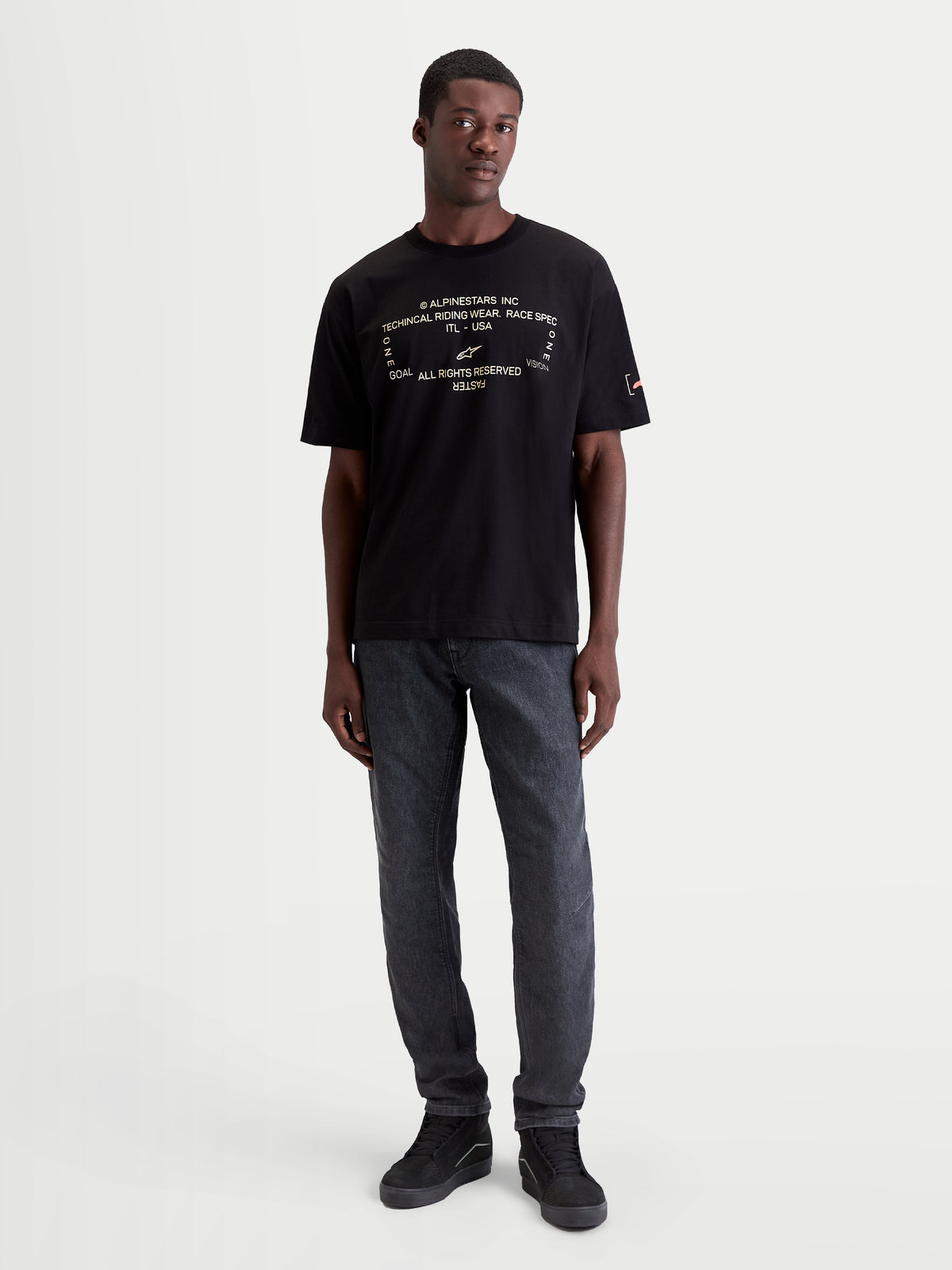 Alpinestars T-Shirt Infinity Oversized CSF, t-shirt sportswear à manches courtes pour homme, noir avec graphique technique blanc sur la poitrine, coupe oversize décontractée, porté par un mannequin, mélange coton et polyester pour le confort quotidien et le style motorsport lifestyle