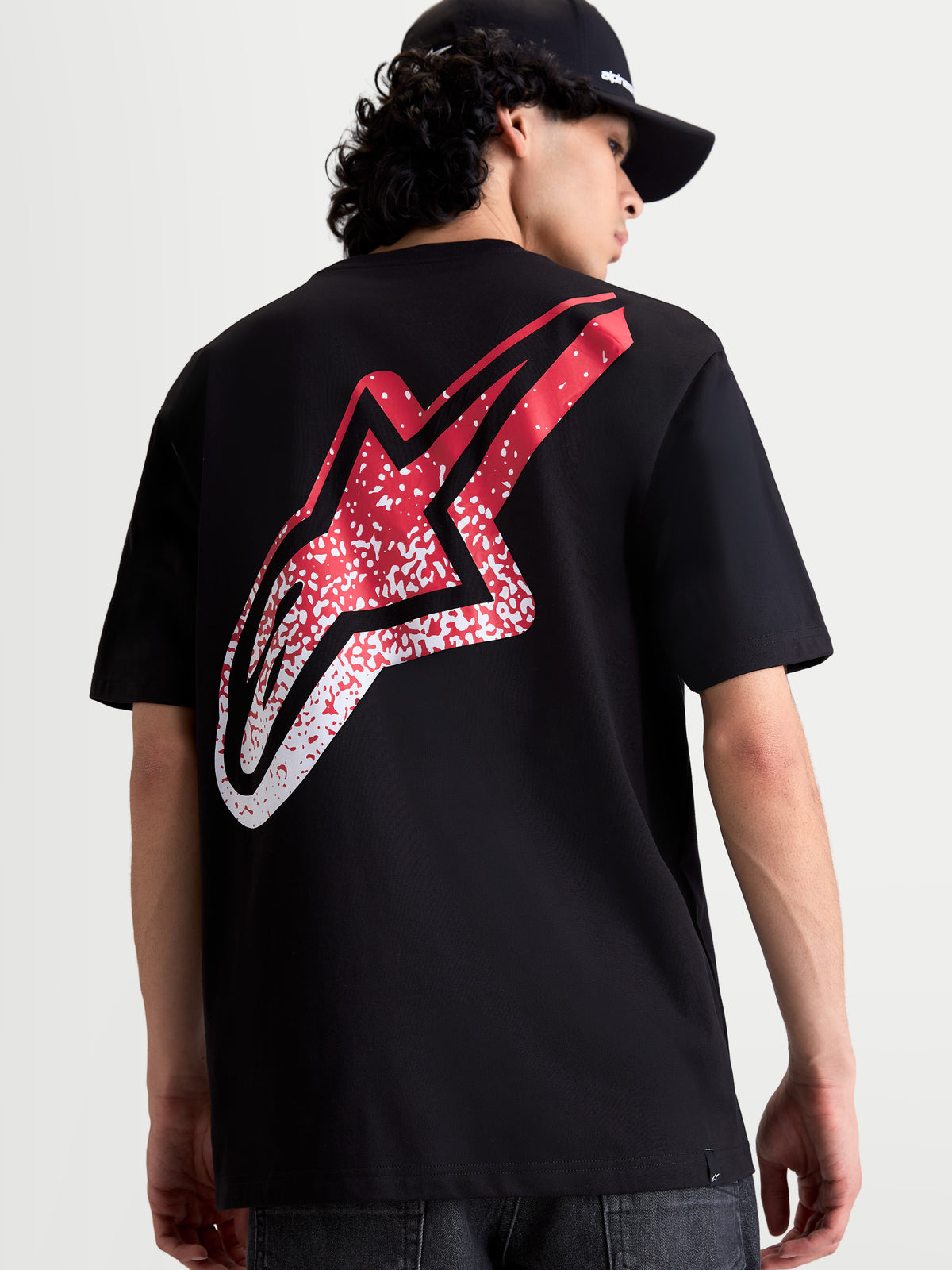 Alpinestars T-Shirt Meteor CSF, t-shirt sportswear noir à manches courtes, vue de dos montrant un grand logo Astars avec dégradé rouge et blanc inspiré du MX, style motorsport décontracté