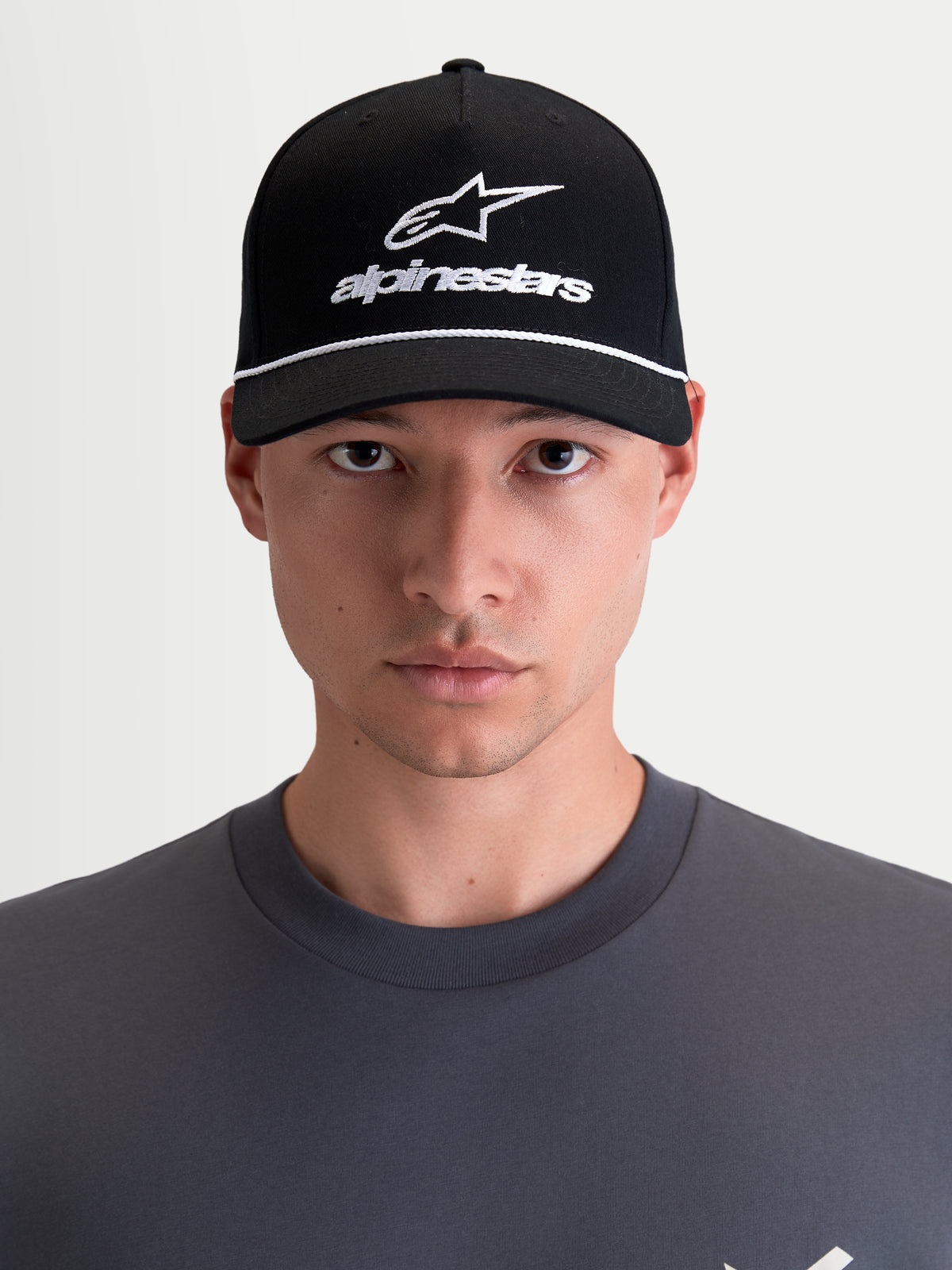 Alpinestars Combo Logo Snapback pet, motorsportpet, unisex, zwart en wit, met gebogen klep, gestructureerde kroon en geborduurd Astars-logo, 100% katoenen keperstof, vooraanzicht op model.