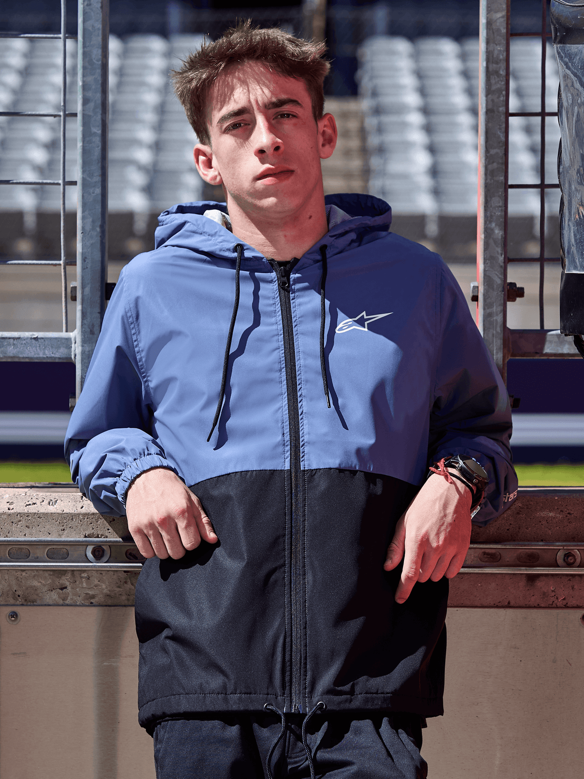 Alpinestars Speeder Windbreaker Jacke, Schieferblau und Schwarz, Kapuzen-Windbreaker im Block-Design, weißes Logo auf der Brust, lässige Lifestyle-Bekleidung an einer Rennstrecke