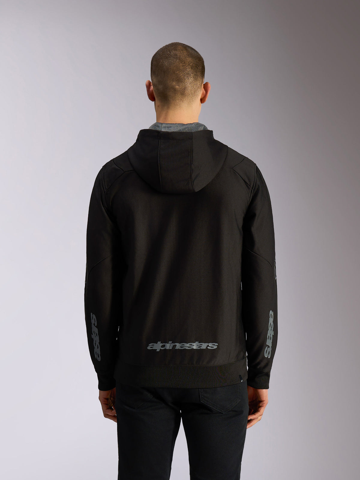 Alpinestars Sessions V3 Hoodie, achteraanzicht, zwarte hoodie met rits, grijs Alpinestars-woordmerk op de onderrug, Astars-branding op de mouwen, geribde zoom en manchetten, casual motorsport streetwear