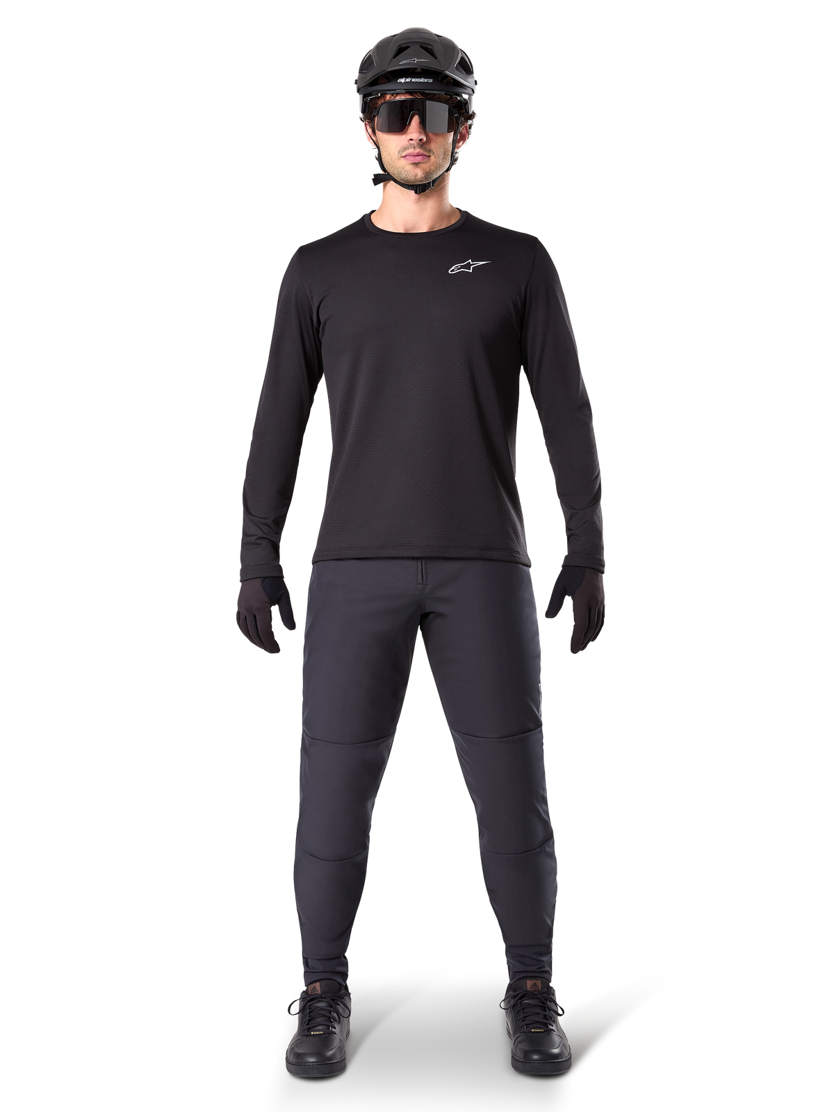 Pantalon thermique Alpinestars A-Dura, noir, porté par un cycliste en tenue complète de VTT avec maillot noir à manches longues, casque et lunettes de soleil, pantalon durable à coupe régulière pour les sorties sur sentier par temps froid