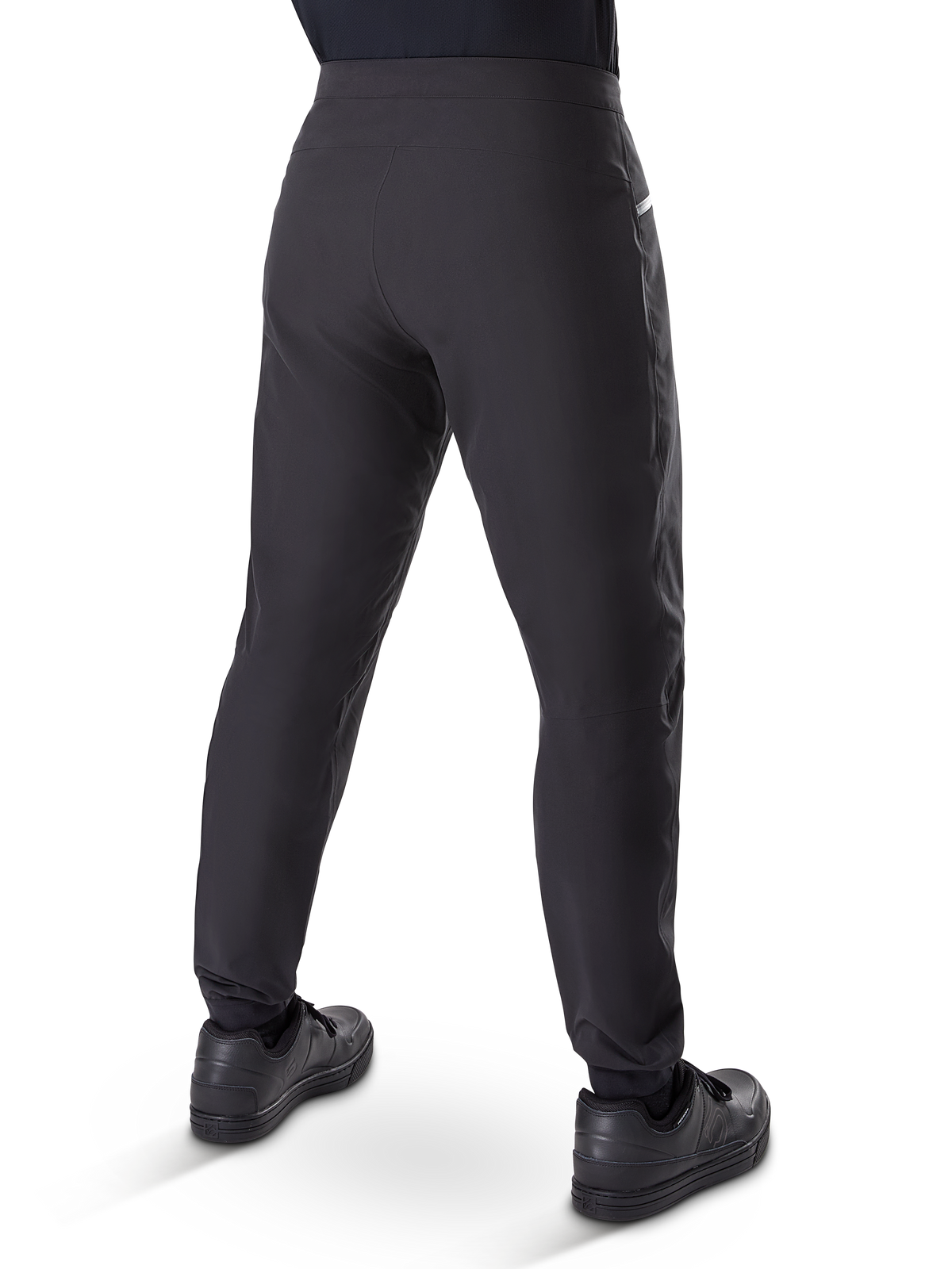 Pantalon imperméable Alpinestars A-Dura, pantalon de VTT, noir, vue arrière porté avec des chaussures noires, doté d'une membrane durable à 3 couches, coupe régulière et poignets élastiqués pour le cyclisme tout-terrain
