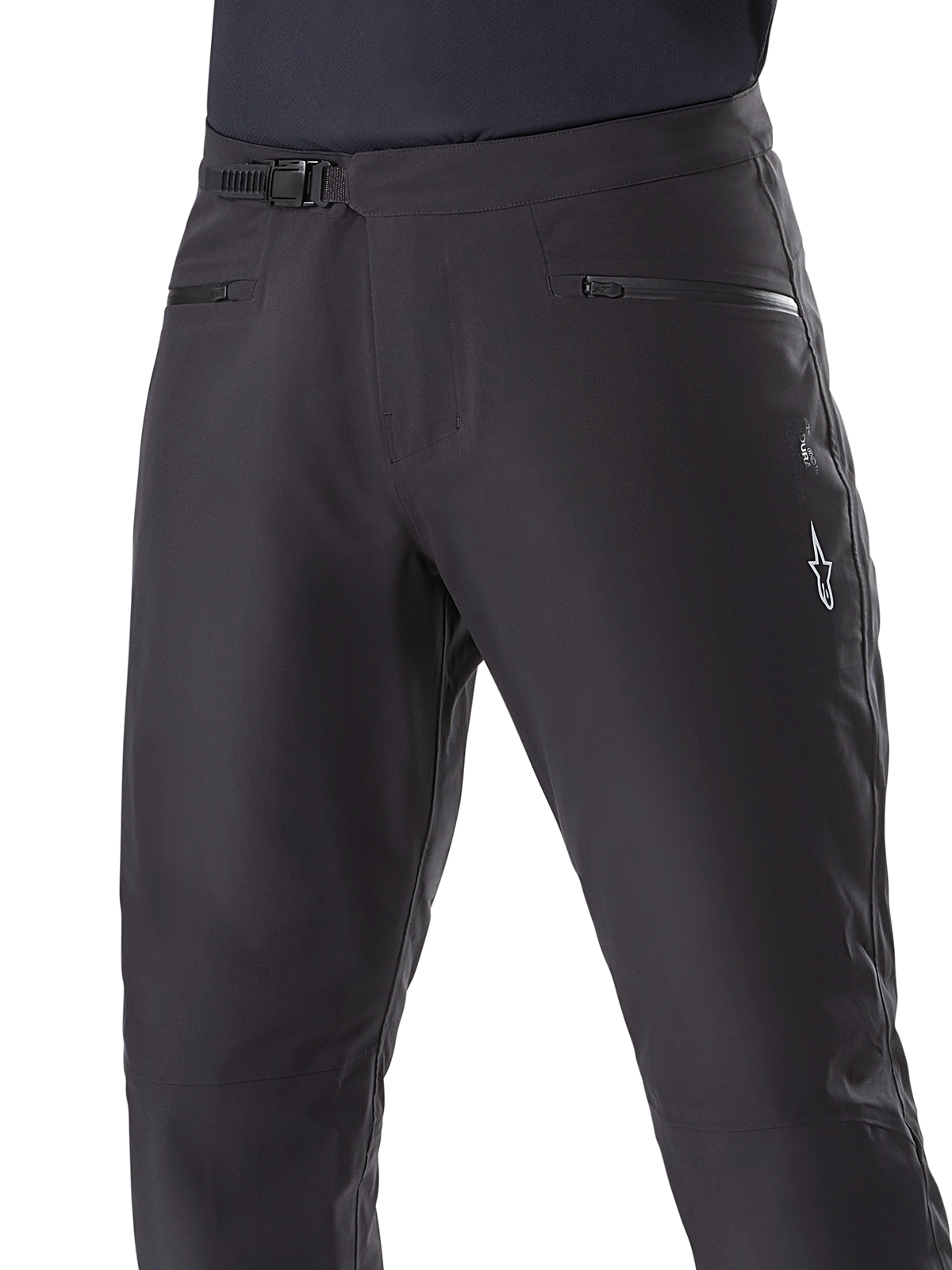 Alpinestars A-Dura Waterproof Pants, mountainbikebroek, zwart, close-up van de taille met ratelsluiting en zakken met rits, met een wit Alpinestars-logo op de dij, duurzaam textiel voor trailrijden in natte weersomstandigheden