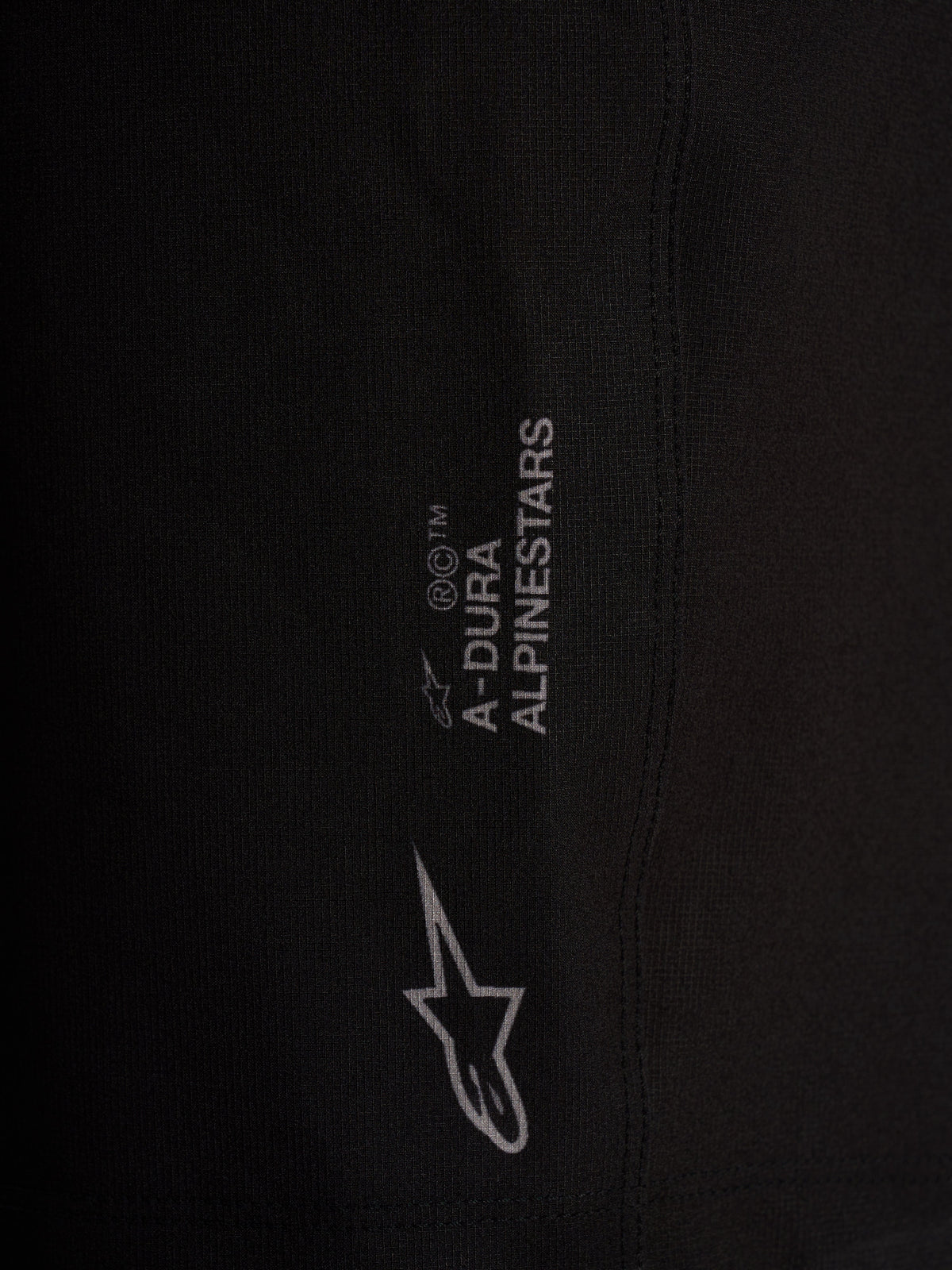 Détail du short Alpinestars A-Dura Ride Liner noir, logos blancs sur tissu technique extensible 4 directions.