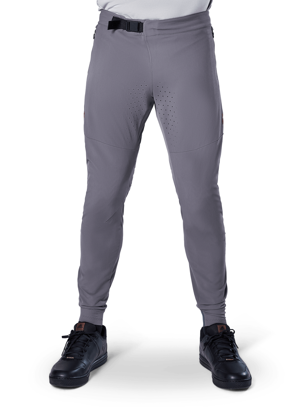 Pantalon Alpinestars A-Aria Elite, pantalon de VTT, gris foncé, doté de perforations laser sur l'intérieur des cuisses pour la ventilation et d'une fermeture par boucle magnétique à la taille, coupe performance avec jambes fuselées, porté avec des chaussures de sport noires