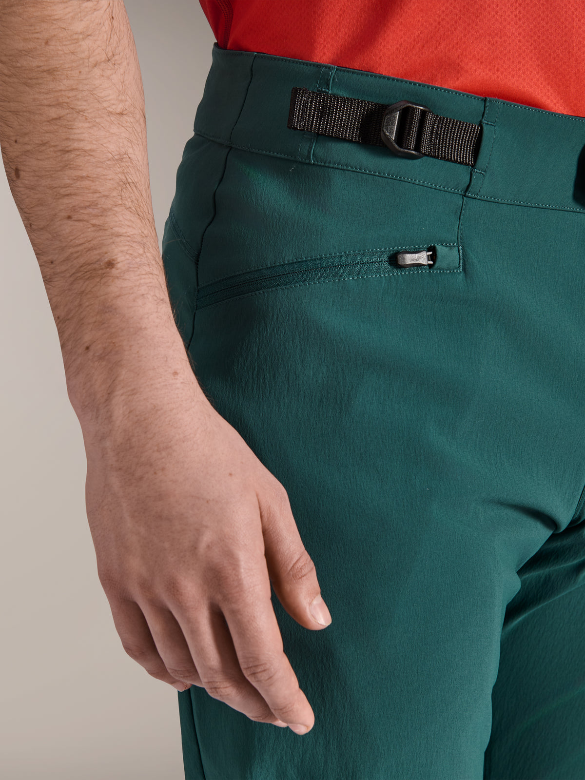 Close-up van de Alpinestars A-Dura broek in Dark Pine groen, met de verstelbare zijsluiting en een met rits afsluitbare mesh-gevoerde zak, duurzame mountainbikekleding voor off-road trailrijden.