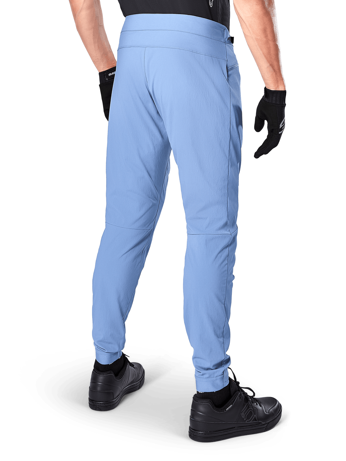 Alpinestars A-Dura Pants, mountainbikebroek, Infinity Blue, achteraanzicht met regular fit en elastische manchetten, gedragen met zwarte handschoenen en zwarte schoenen, duurzame fietskleding met 2-way stretch