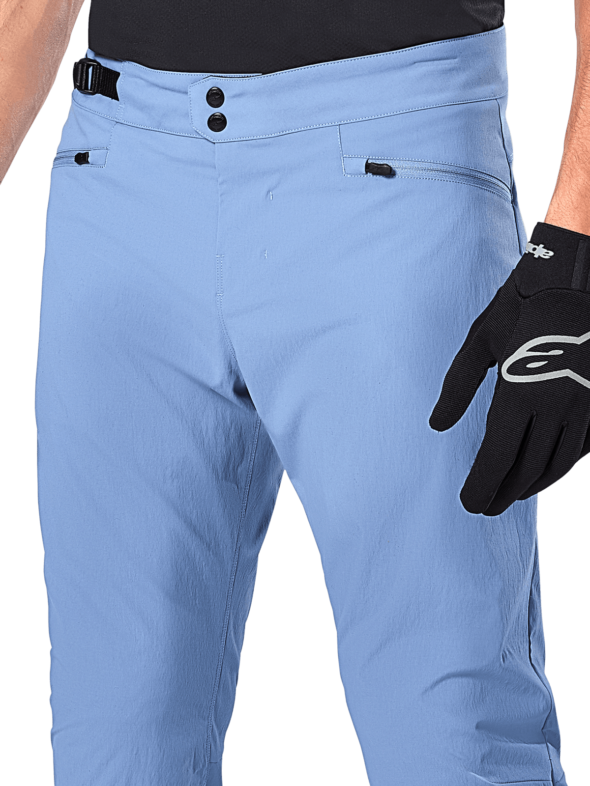 Alpinestars A-Dura Pants, MTB-fietsbroek, Infinity Blue, close-up van de taille met dubbele drukknoopsluiting en verstelbare tailleband aan de zijkant, zakken met rits, gedragen met zwarte Alpinestars handschoenen