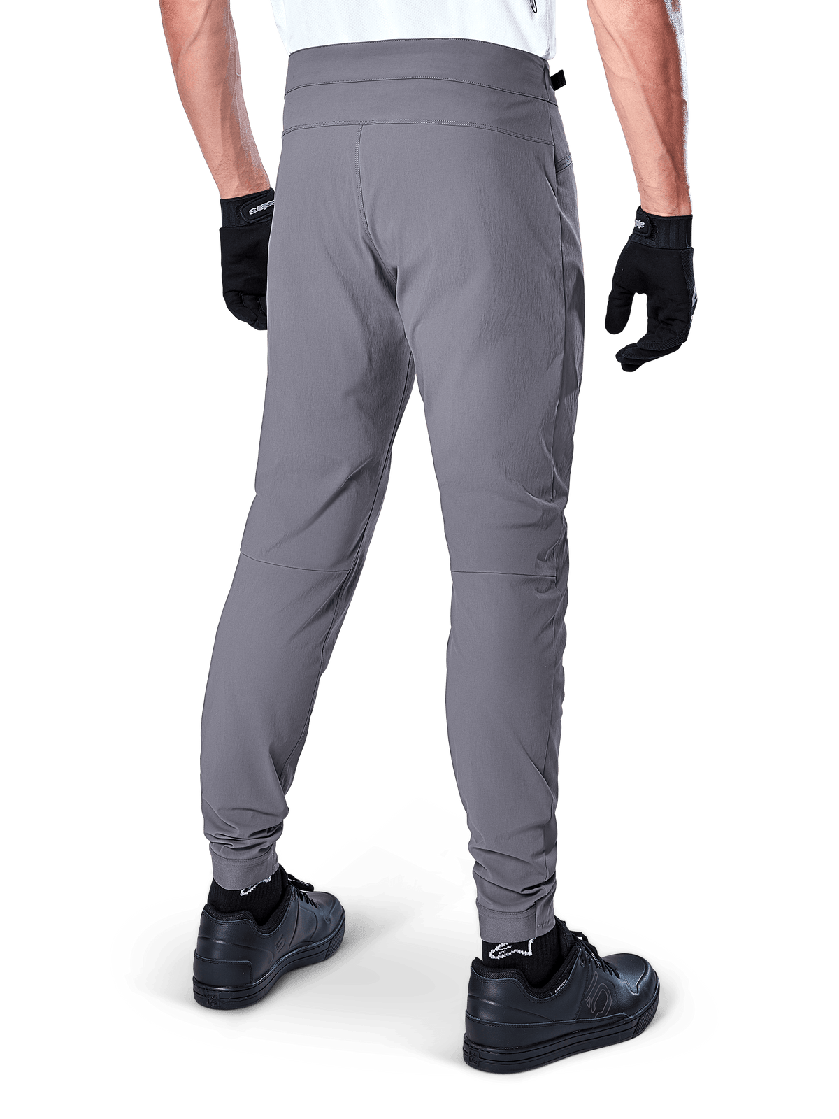 Alpinestars A-Dura Pants, Mountain Bike Pants, Dark Gray, rear view of model wearing the gear, featuring a durable 2-way stretch fabric and elasticated cuffs, coordinated with black gloves and sneakers for a cycling-ready look