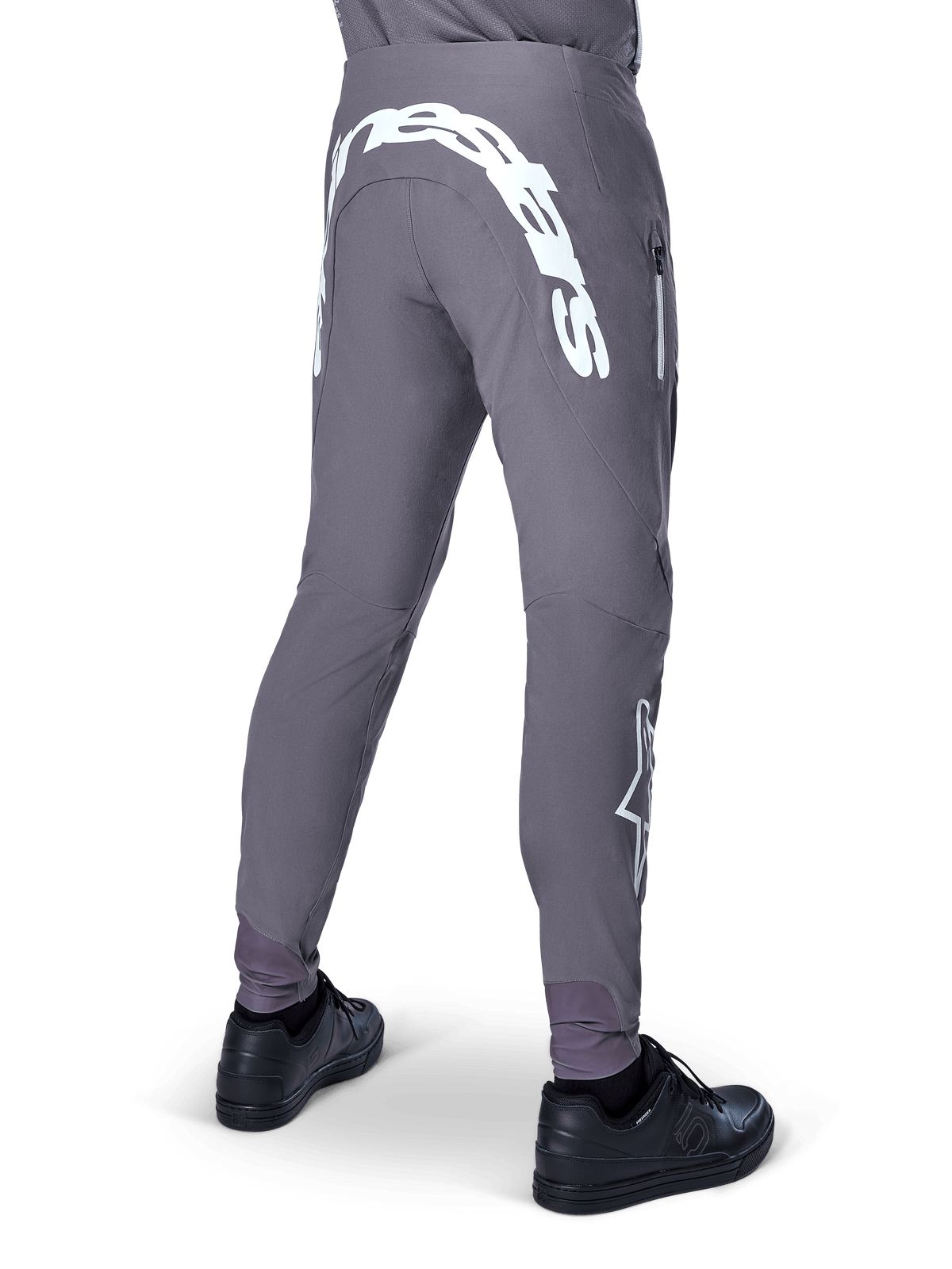 Alpinestars A-Supra Race Pants, Mountain Bike Pants, Dark Gray, rear view worn with black shoes, featuring a large white Alpinestars wordmark on the back yoke and star logo on the leg, zippered pocket, performance stretch fabric for MTB racing