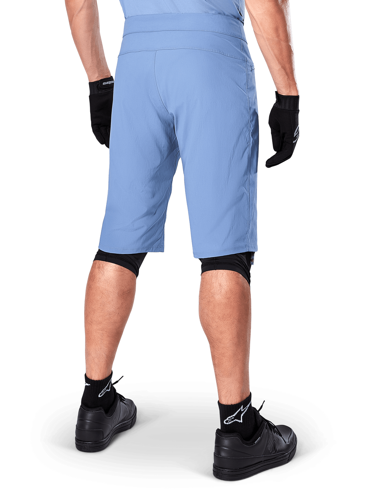 Short Alpinestars A-Dura, short de VTT bleu Infinity, vue de dos, associé à des gants noirs, des protections de genoux et des chaussettes noires avec logo étoile blanc, matériau extensible durable pour le cyclisme tout-terrain