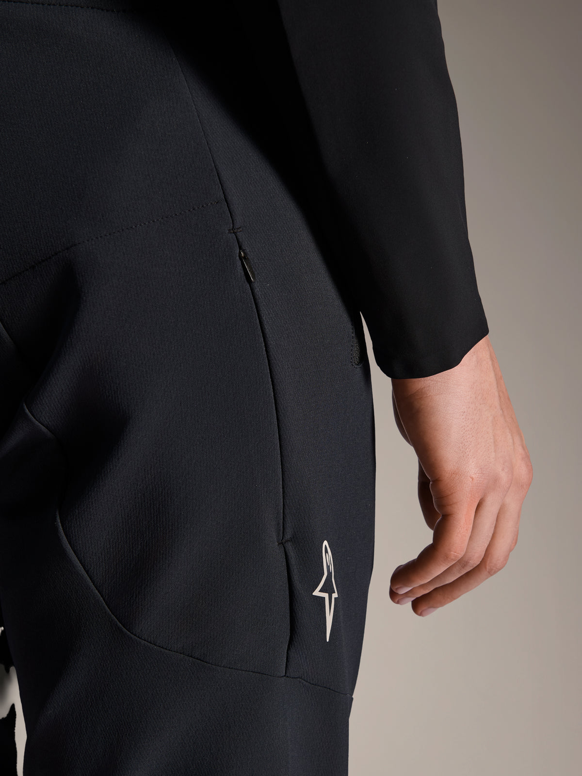 Nahaufnahme der Alpinestars A-Aria Elite Hose in Black Titanium, mit einer seitlichen Reißverschlusstasche und kleinem weißen Stern-Logo, technische Mountainbike-Hose für leistungsorientiertes Radfahren
